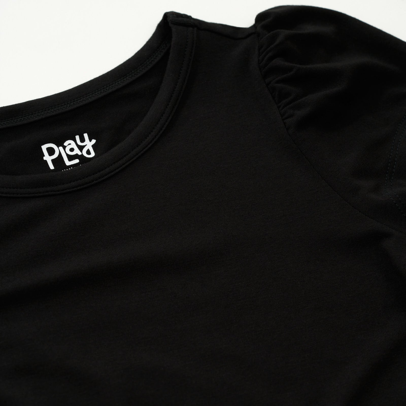 Close up flat lay of the shoulder detail on the Black Puff Sleeve Tee
