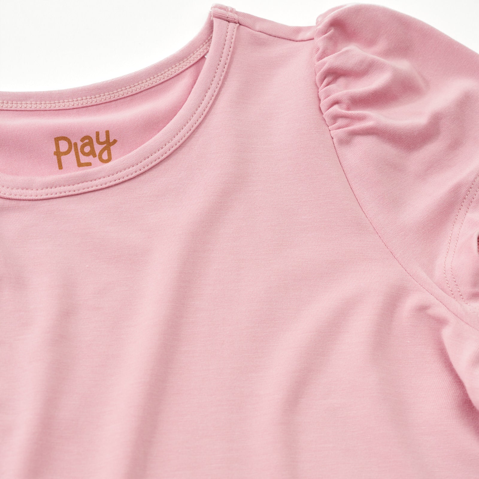 Close up flat lay of the shoulder detail on the Mauve Blush Puff Sleeve Tee