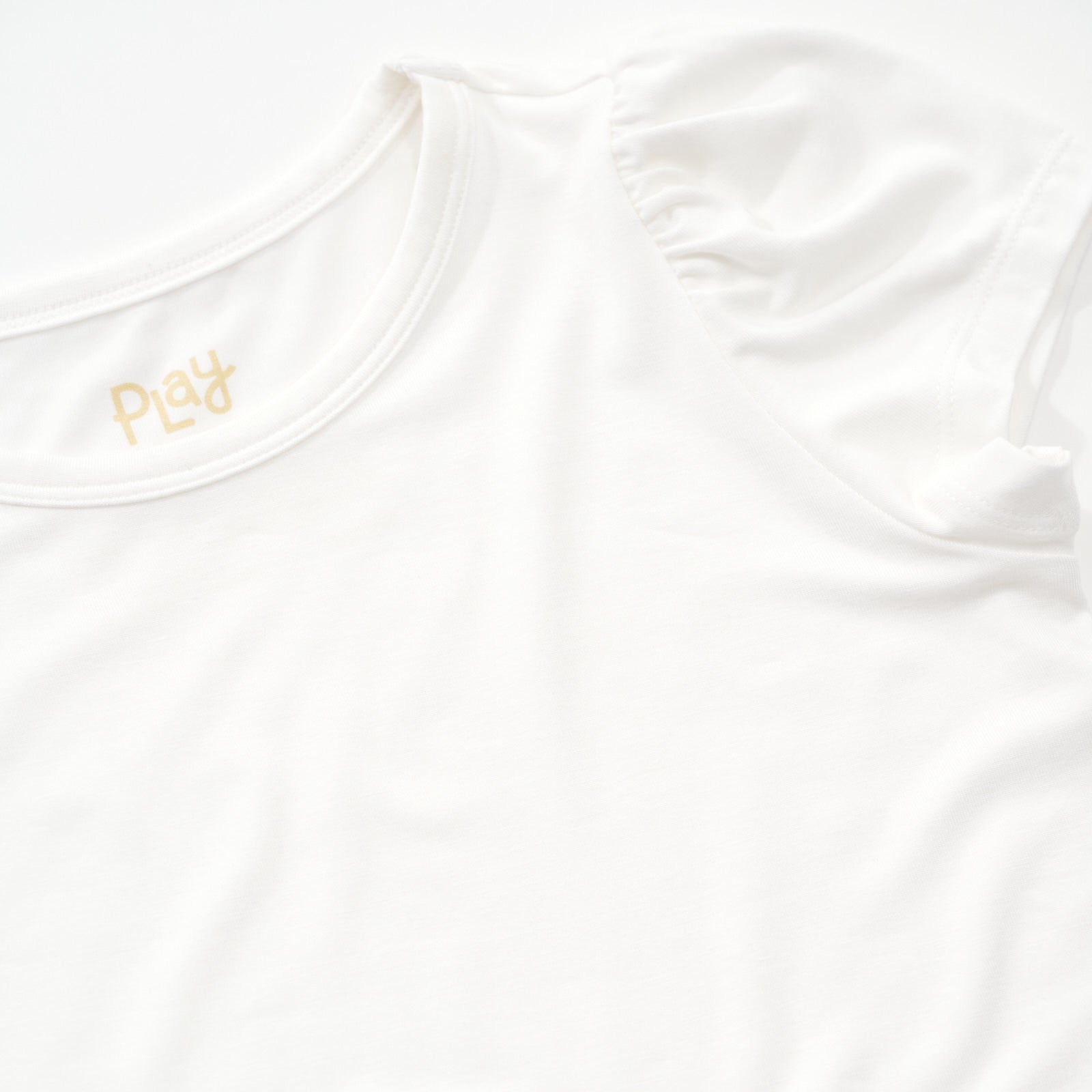 Close up of the puff sleeve on a Soft white puff sleeve tee