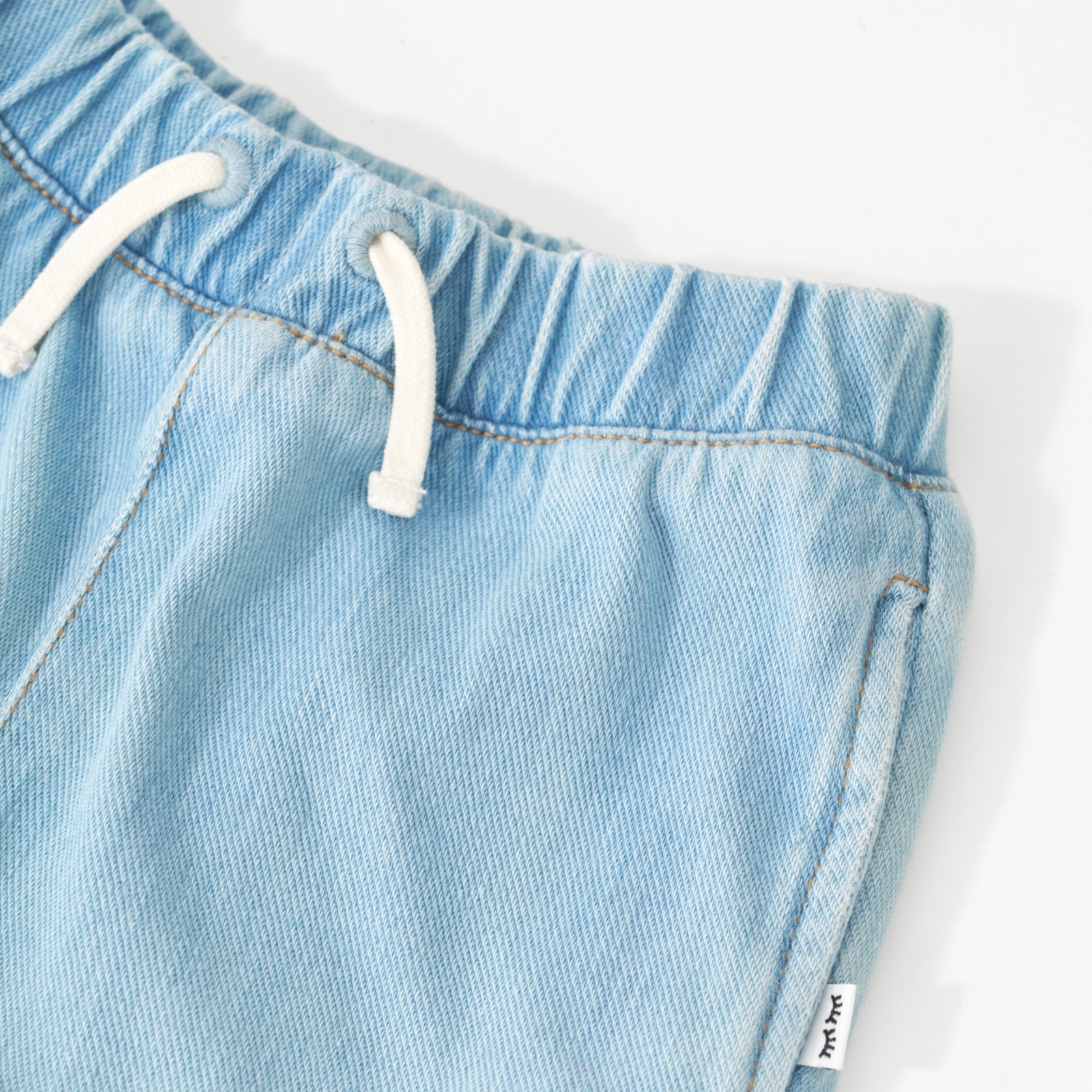 Close up image of drawstring detail on the Light Blue Denim Shorts