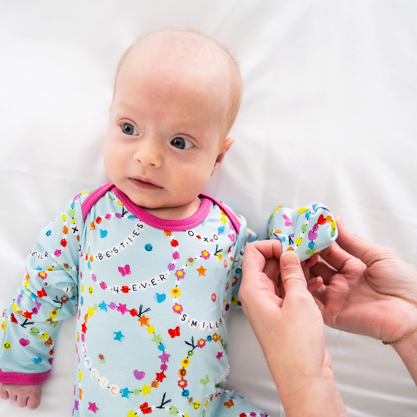 Adult demonstrating the fold over hand detail on the Friends Forever Infant Gown