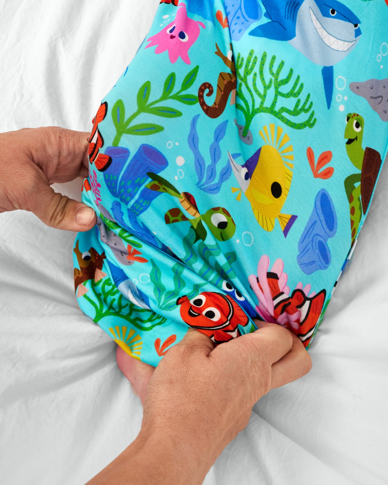Adult demonstrating the envelop sweep on the Pixar Nemo's Reef Infant Gown