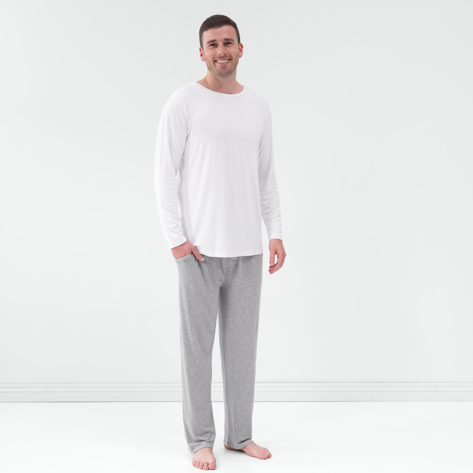 Standing man wearing the Bright White Men's Pajama Top with gray pajama pants