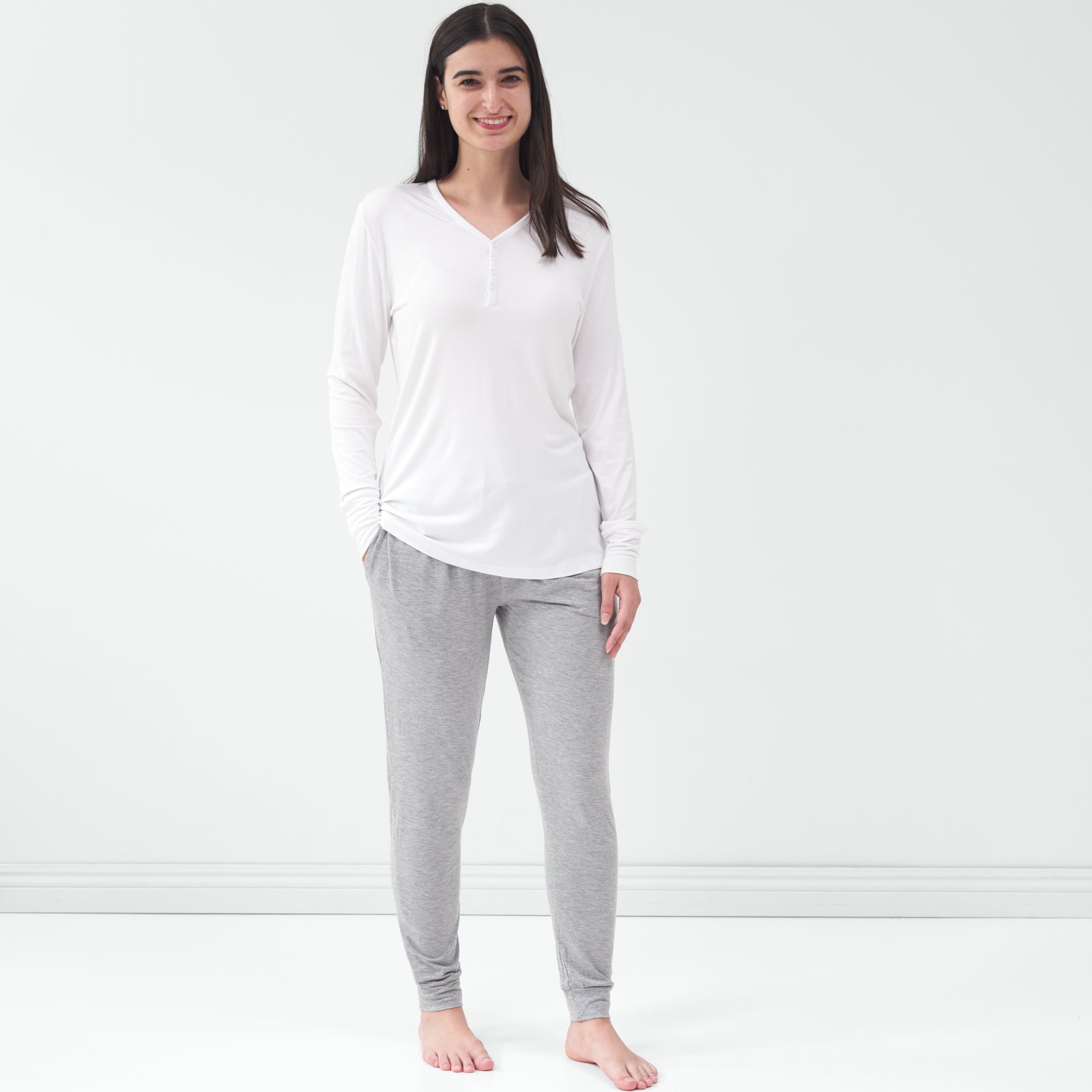 Standing woman wearing the Bright White Women's Pajama Top with gray pajama pants