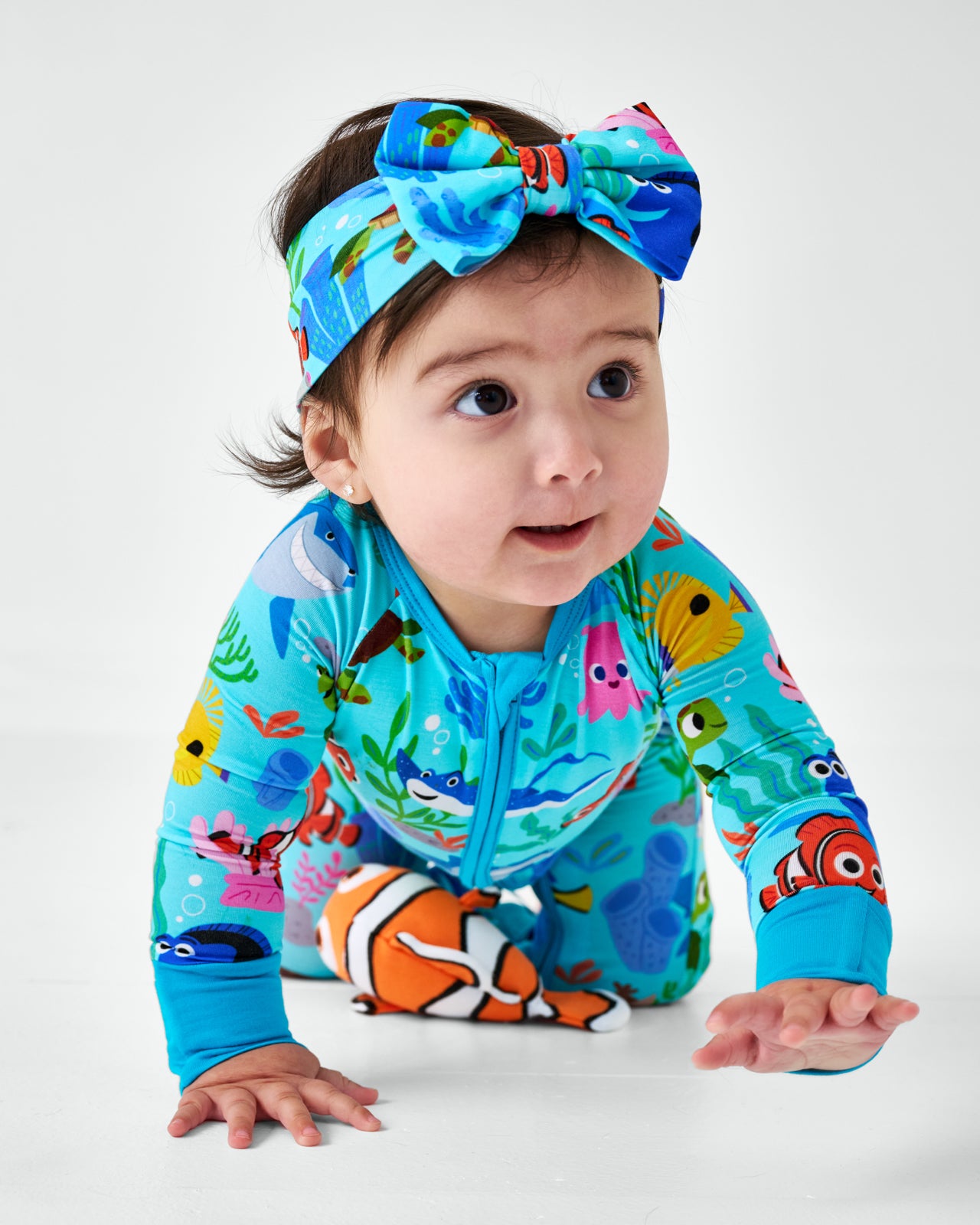 Crawling child wearing the Disney Nemo's Reef Luxe Bow Headband with the Nemo's Reef Zippy