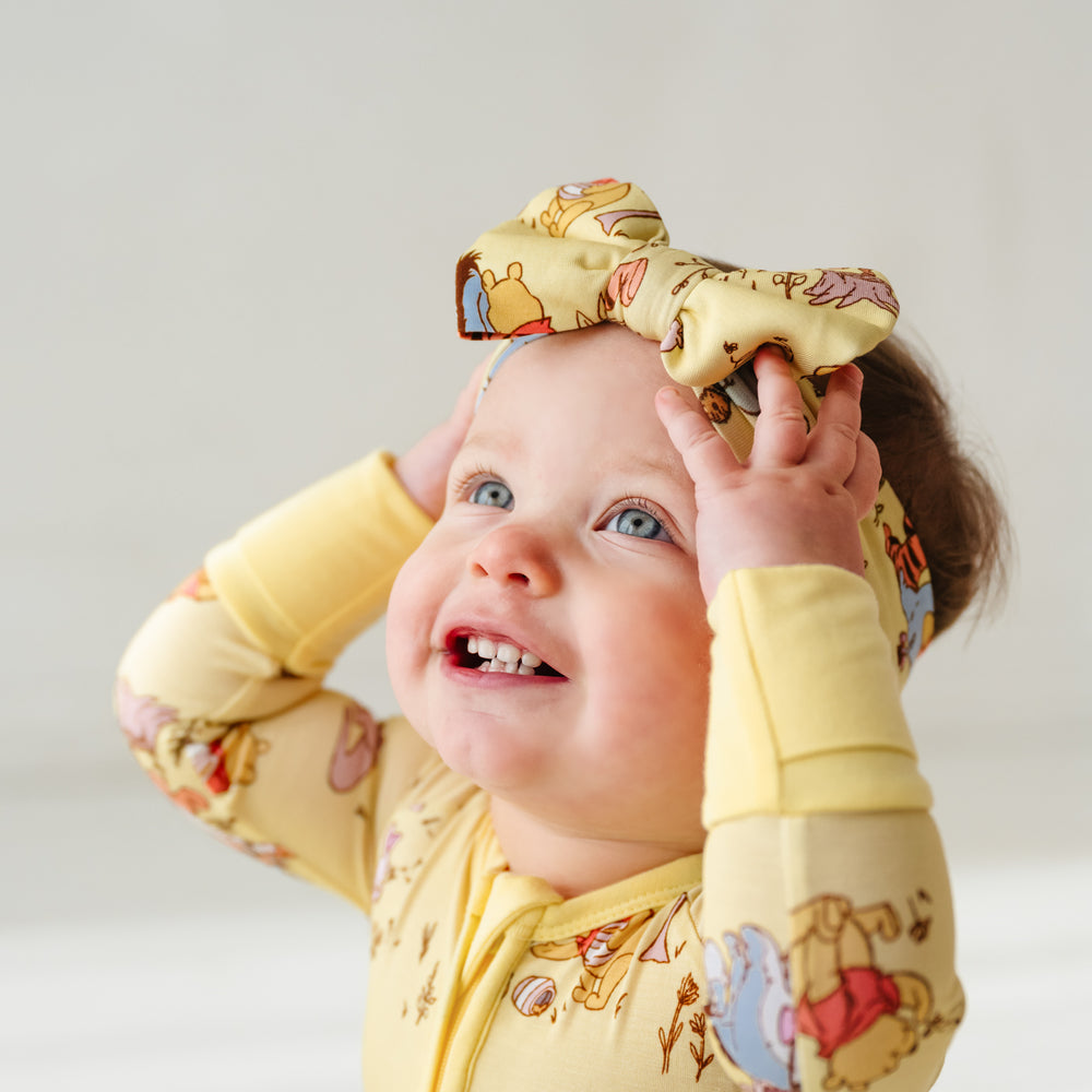 Alternate close up image of a child wearing a Playtime with Pooh luxe bow headband