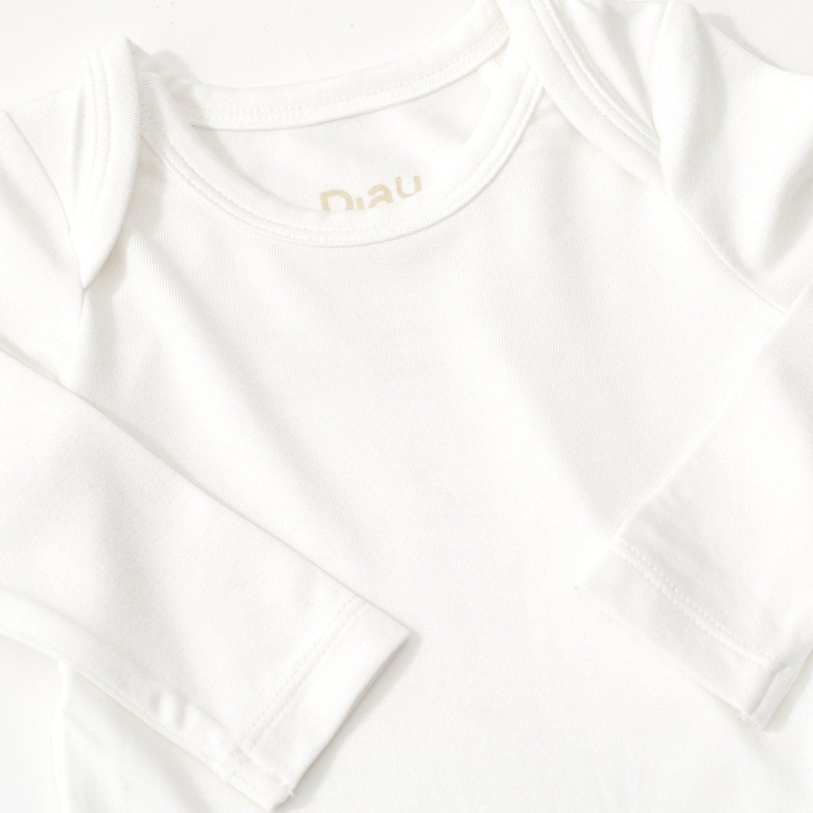 Close up flat lay of the shoulder detail on the Soft White Bodysuit