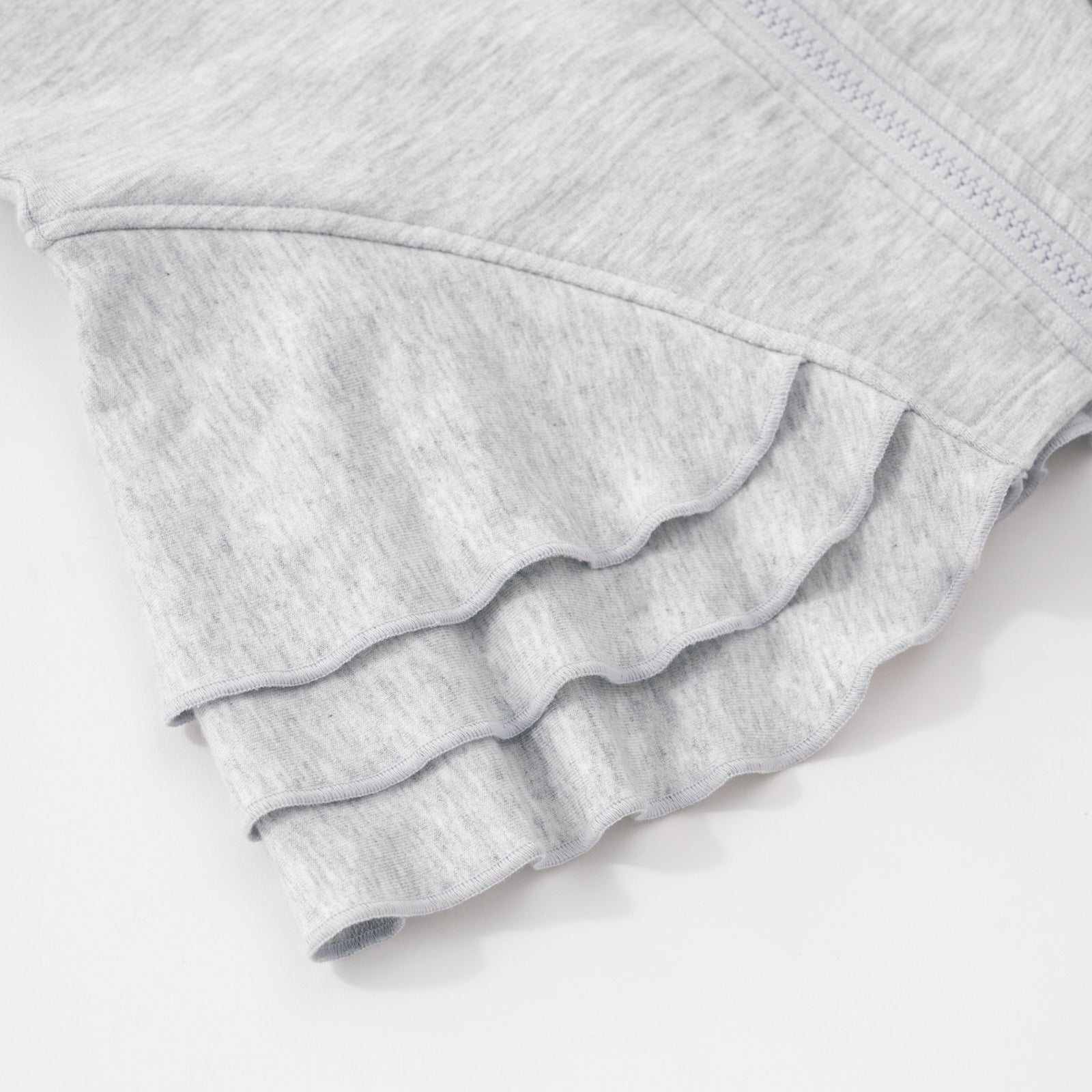 Close up flat lay of the side peplum detail on the Light Heather Gray Peplum Hoodie