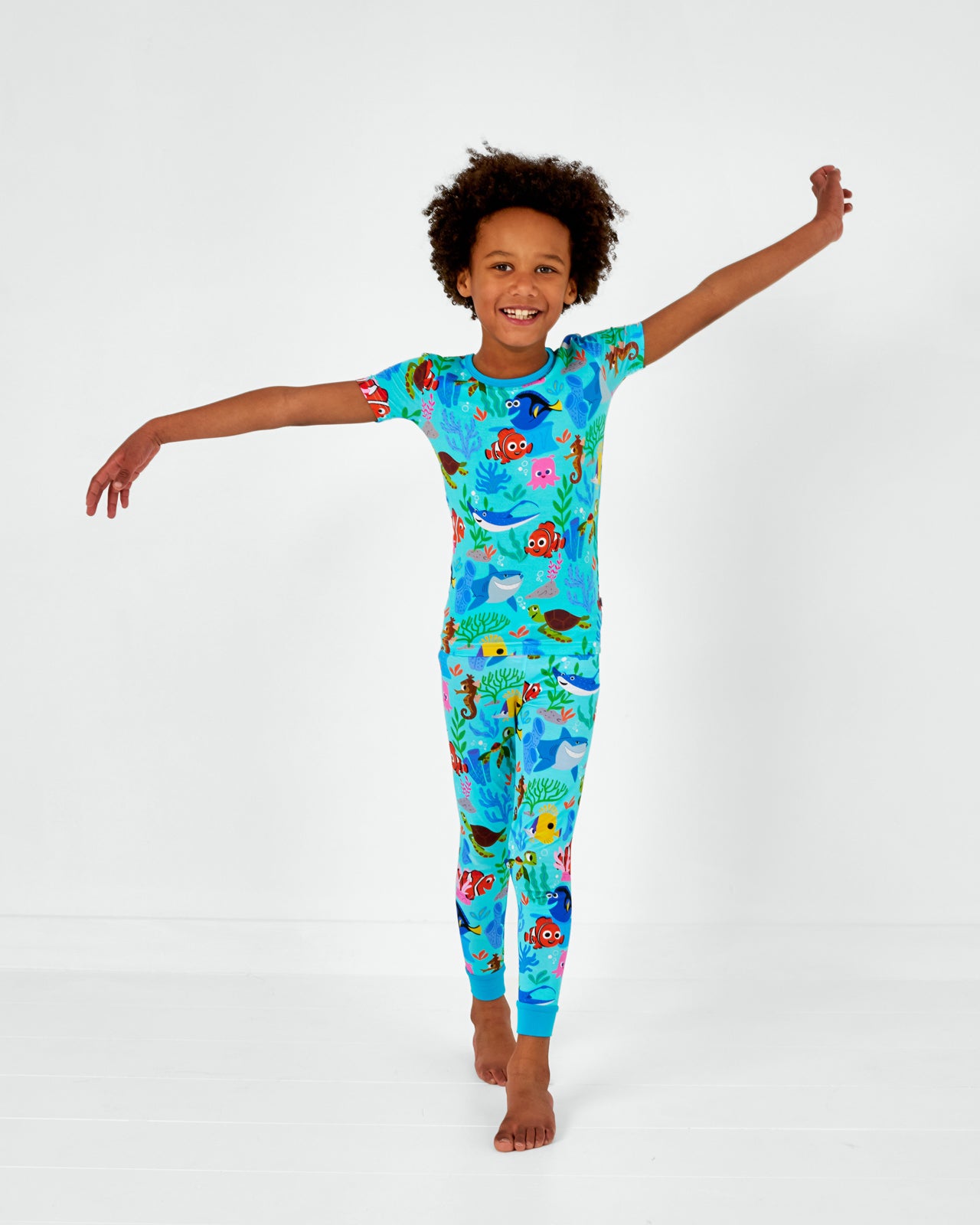 Posing child wearing the Disney Nemo's Reef Two-Piece Short Sleeve bamboo Pajama Set