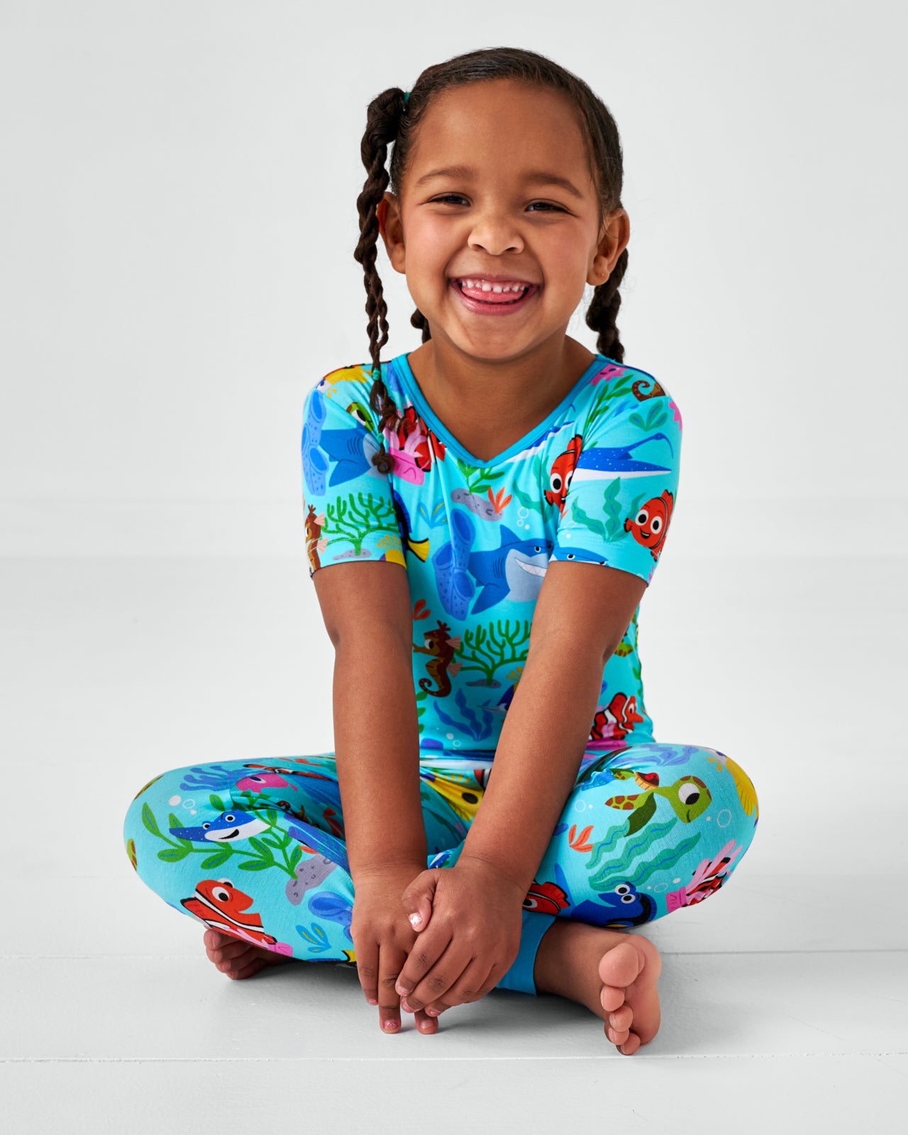 Sitting child wearing the Disney Nemo's Reef Two-Piece Short Sleeve Pajama Set
