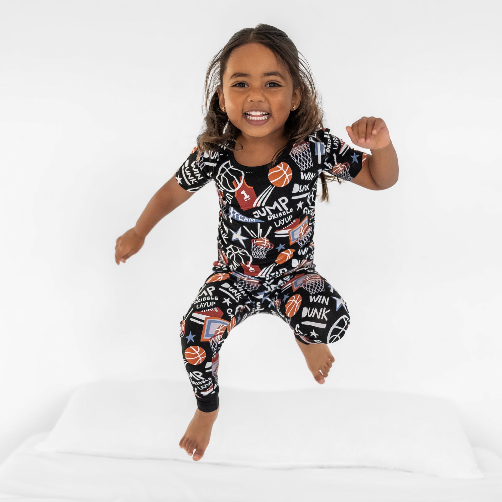 Child jumping on bed wearing a Black Slam Dunk bamboo short sleeve pajama set