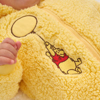 Close up image of a child wearing a Disney Winnie the Pooh sherpa romper detailing the embroidered image of Winnie the Pooh