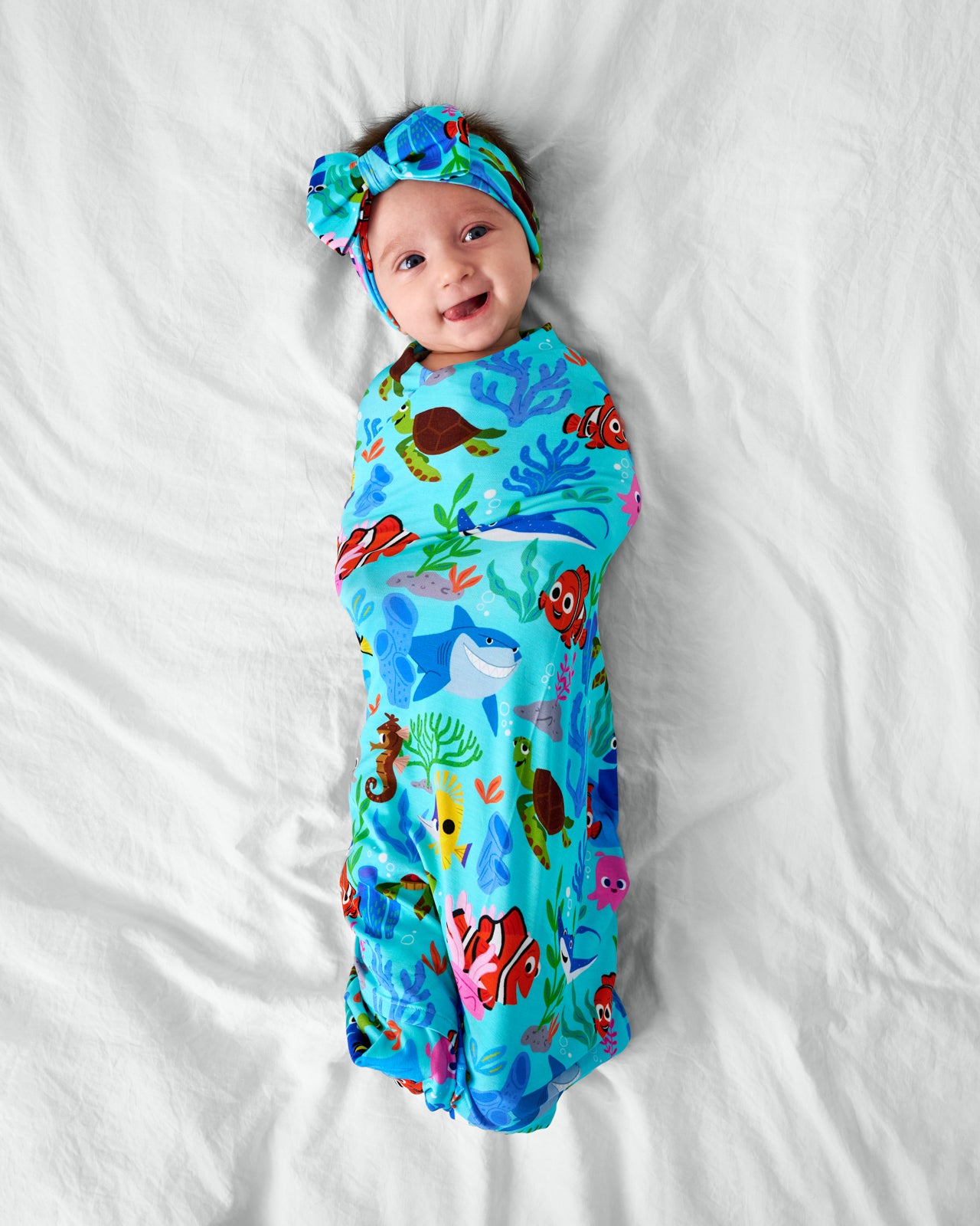 Ariel view of baby in the Disney Nemo's Reef Swaddle & Luxe Bow Headband Set
