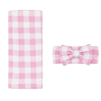 Flat lay image of a Pink Gingham swaddle and luxe bow headband set