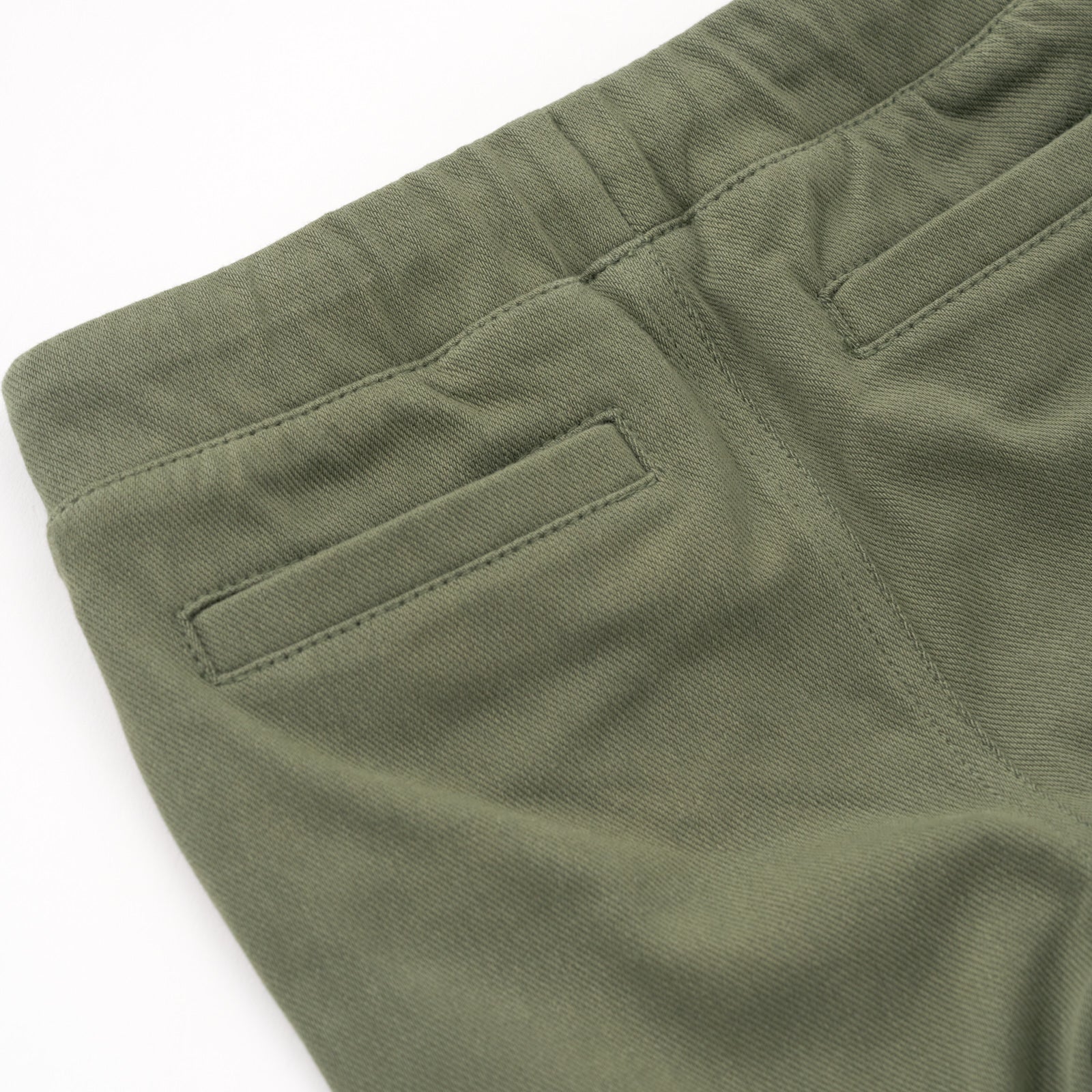 Close up flat lay of the back pocket details on the Olive Denim Jogger