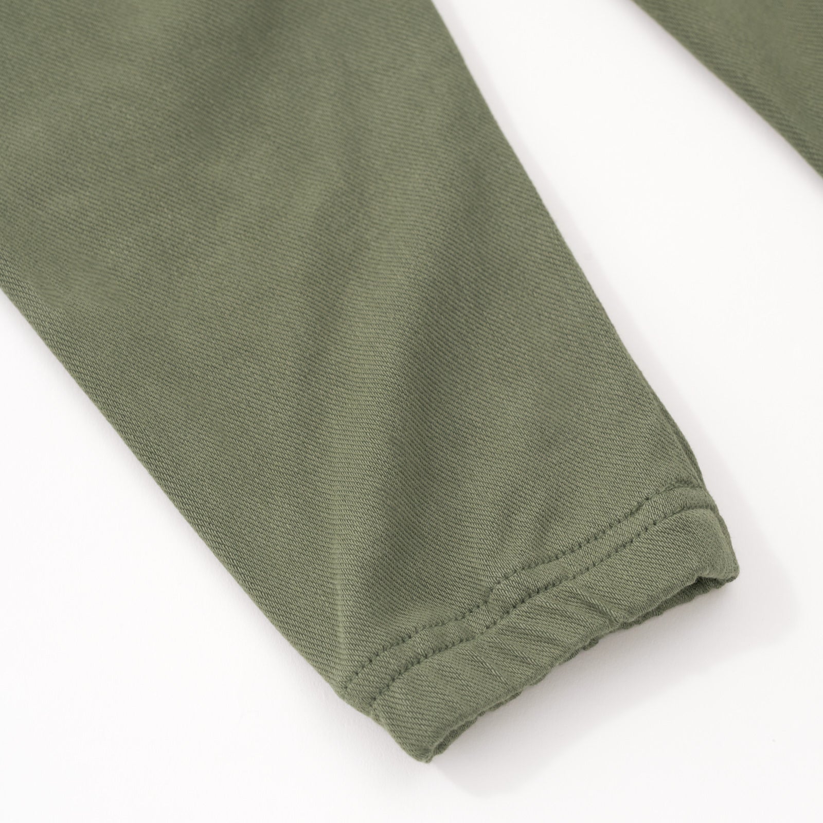 Close up flat lay of the ankle detail on the Olive Denim Jogger