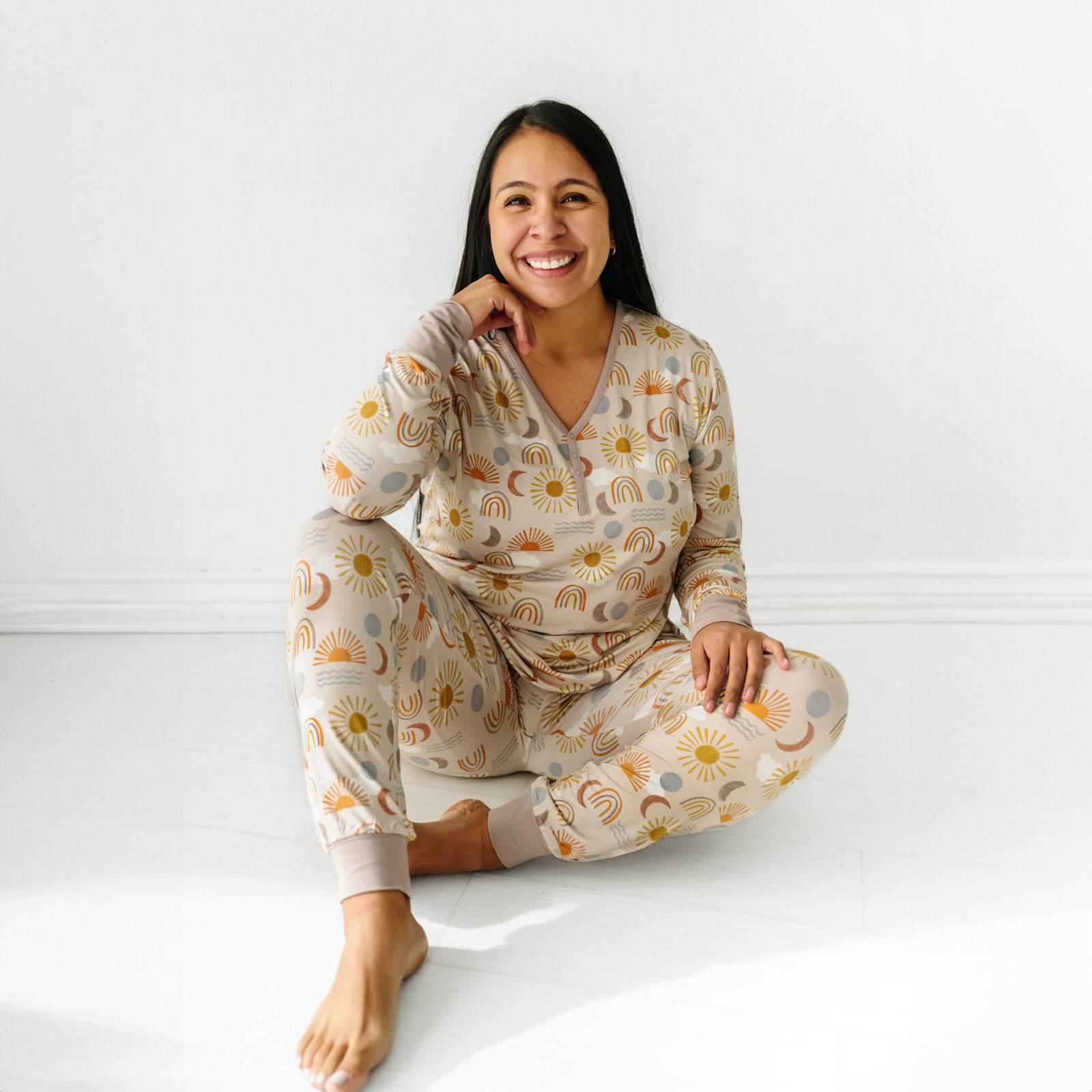Woman sitting wearing a Desert Sunrise women's pajama top paired with matching women's pajama pants
