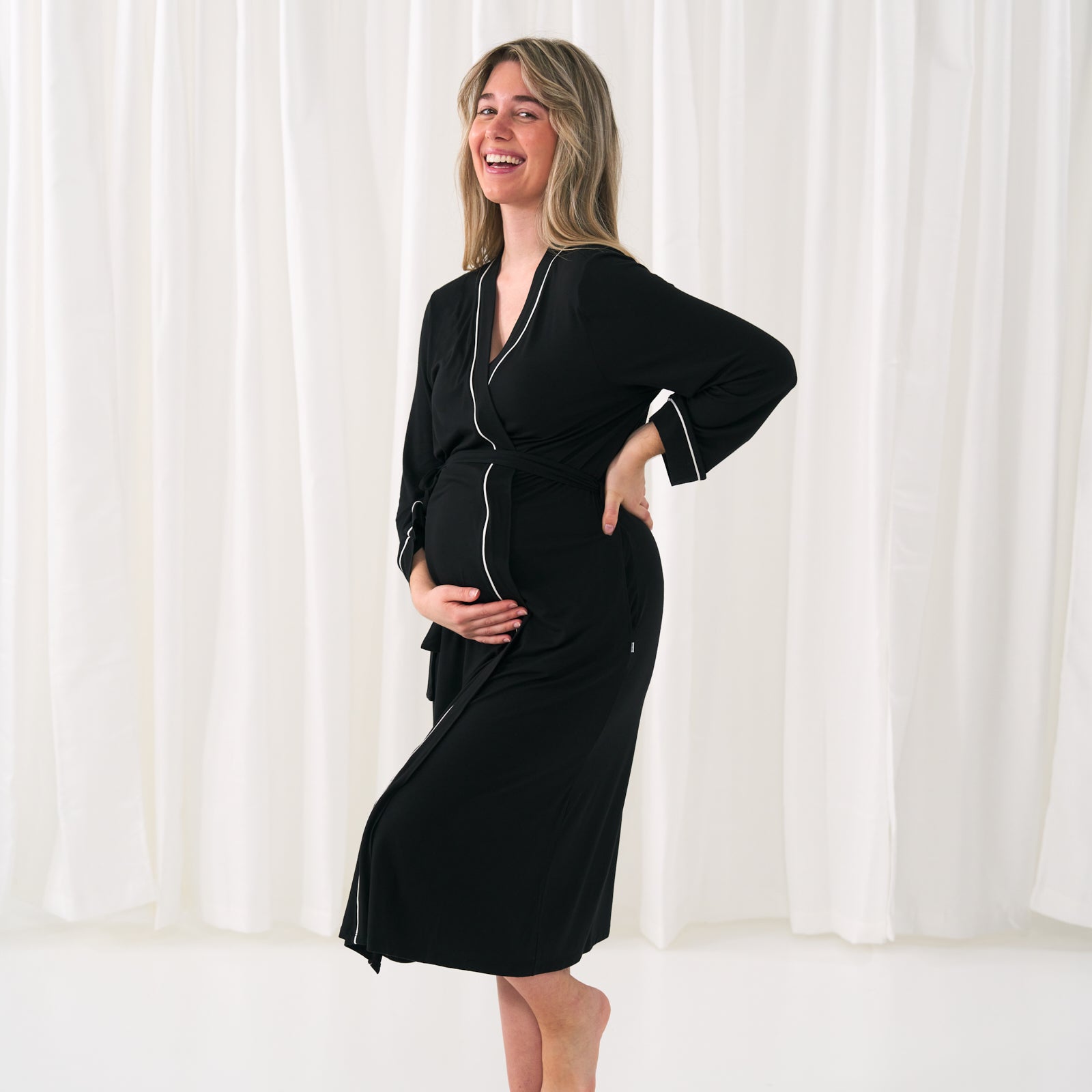 woman holding her baby bump wearing a women's black robe