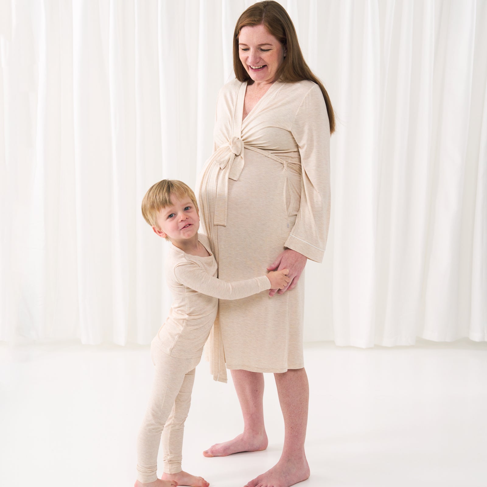 woman wearing a Heather Oatmeal women's robe, her child is matching wearing a Heather Oatmeal two piece pajama set