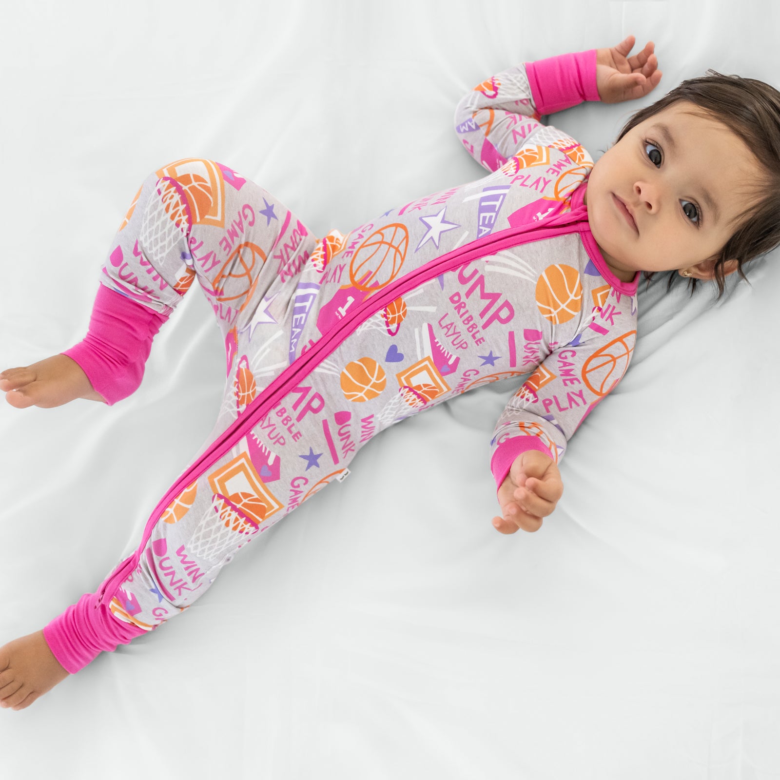 Child laying wearing the Pink Slam Dunk zippy