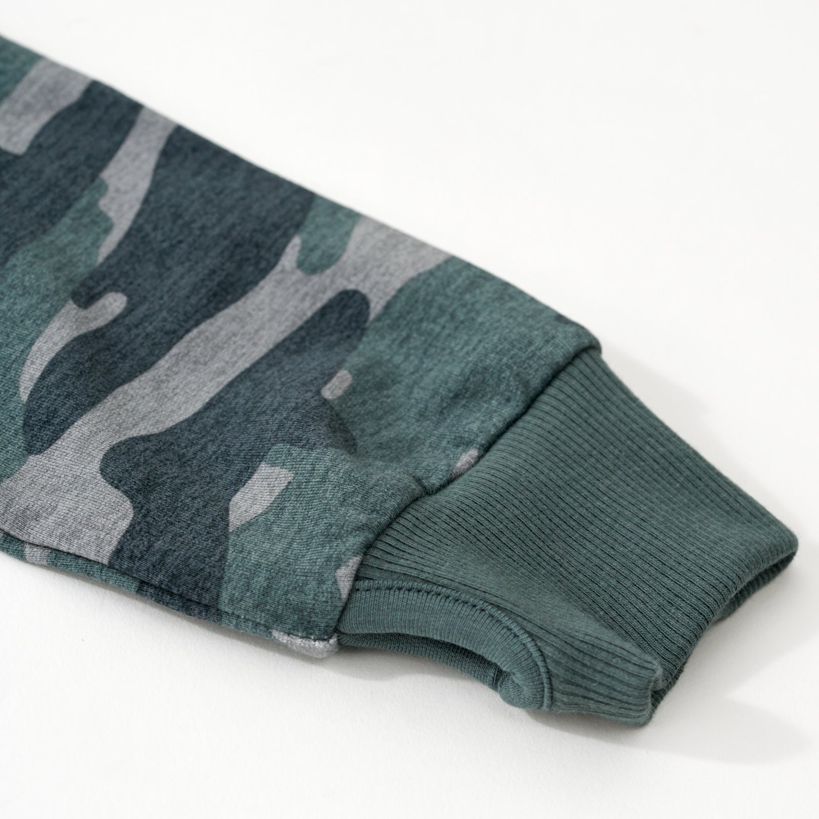 Close up flat lay of the sleeve and thumb hole detail on the Vintage Camo Zip Hoodie