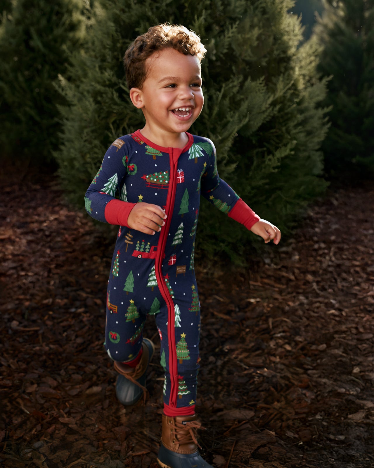 Child running at a Christmas Tree farm wearing the Navy Tree Traffic Zippy