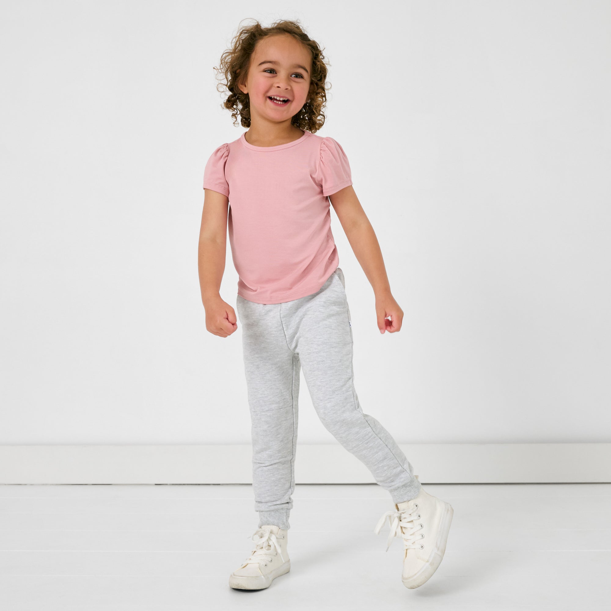 Standing girl wearing the Light Heather Gray Jogger with a pink puff sleeve tee