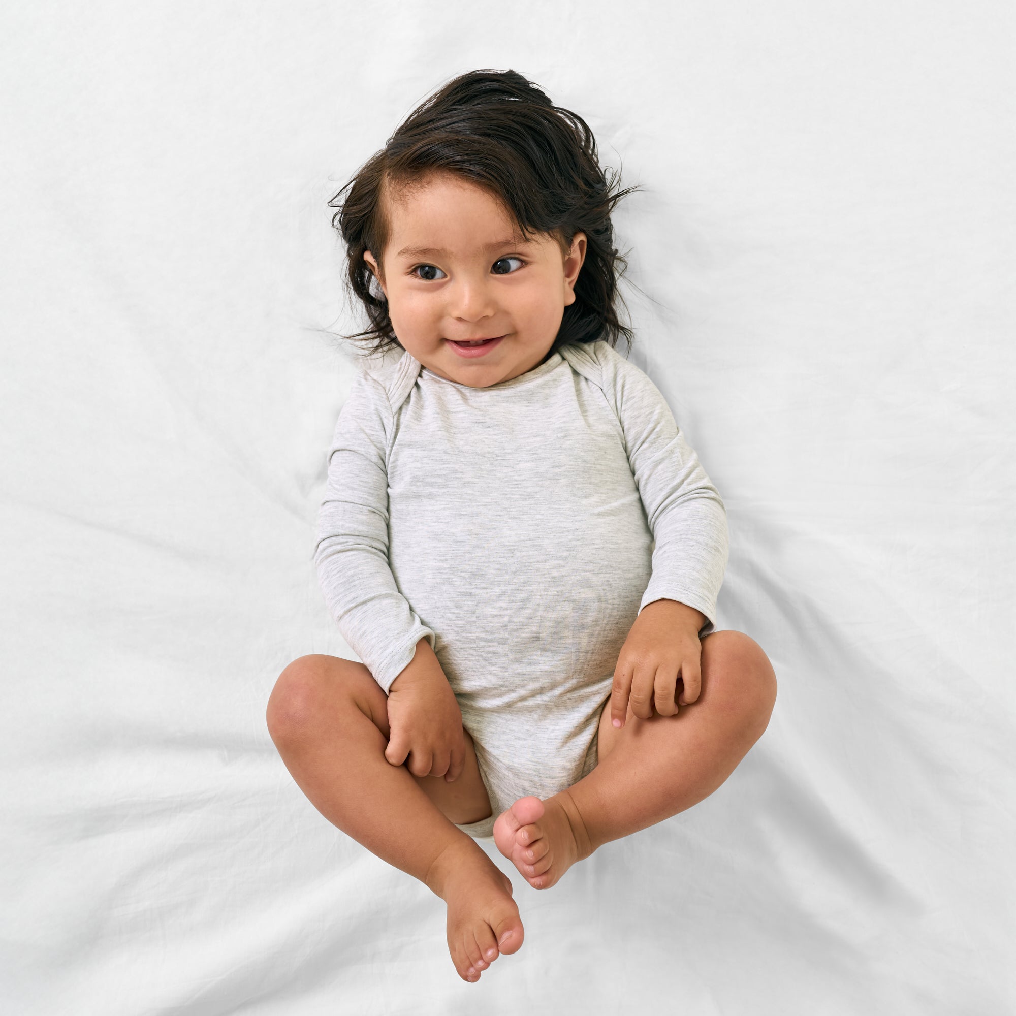 Aerial view of child wearing the Light Heather Gray Long Sleeve Bodysuit