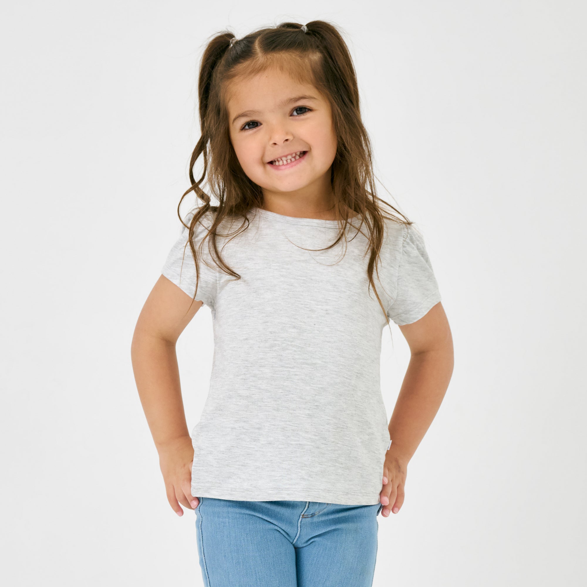 Close up of child wearing the Light Heather Gray Puff Sleeve Tee with blue denim pants
