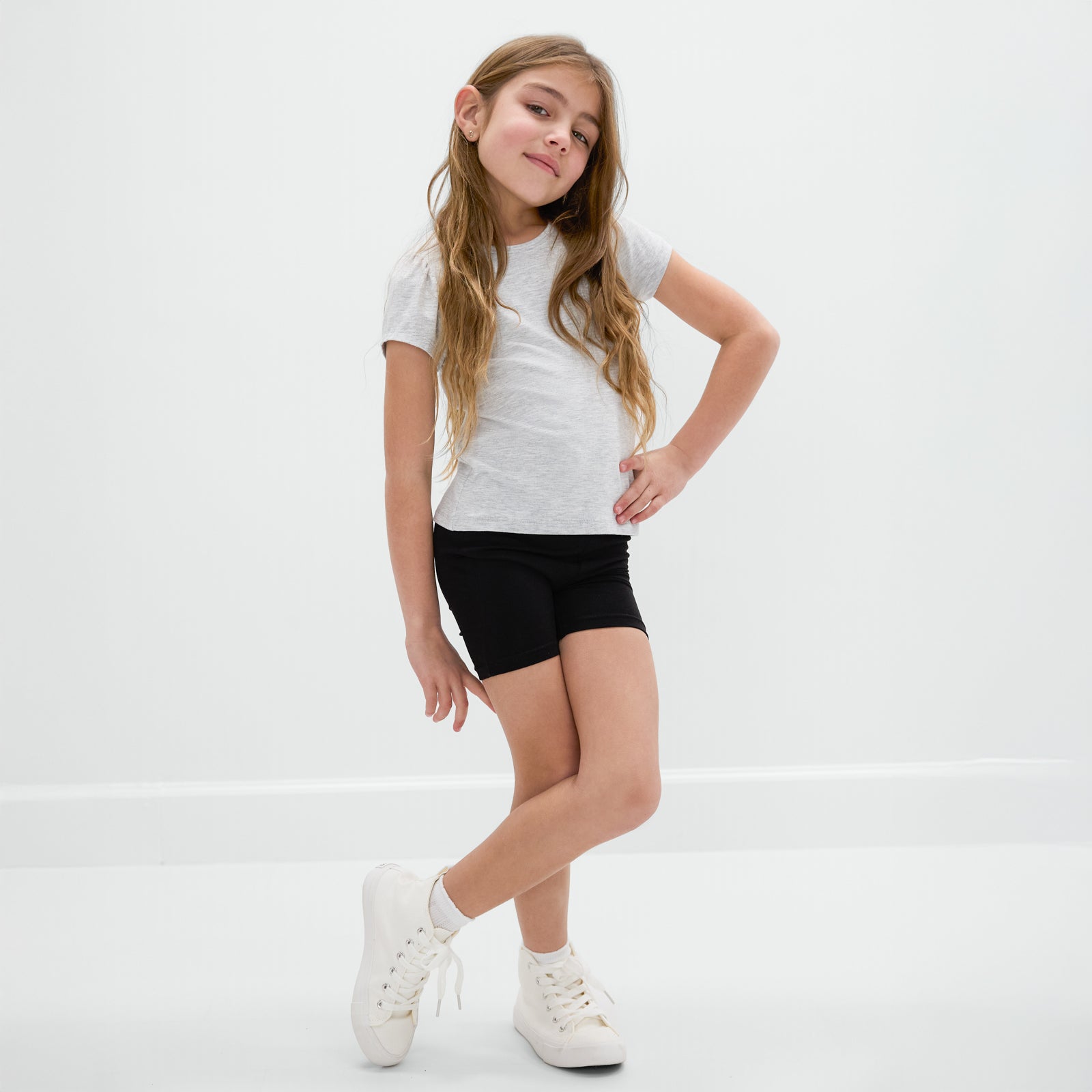 Posing child wearing the Black Bike Shorts with a light gray bamboo tee