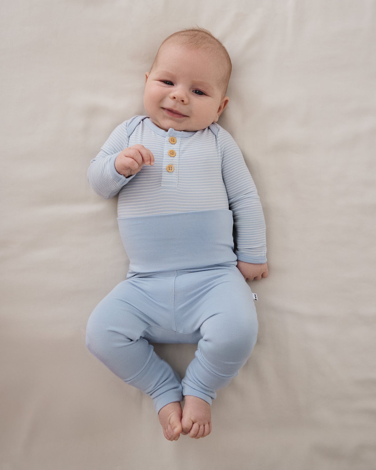 Overhead view of newborn baby wearing the Light Fog Fold Over Legging