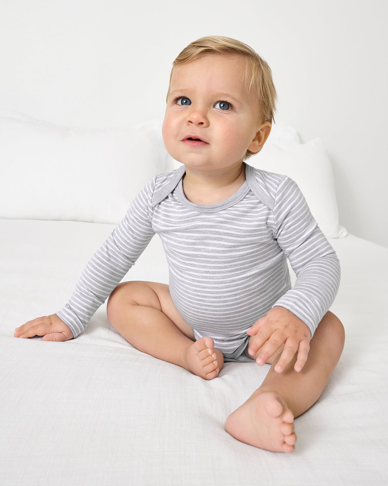 Sitting baby wearing the Light Heather Gray Stripe Bodysuit