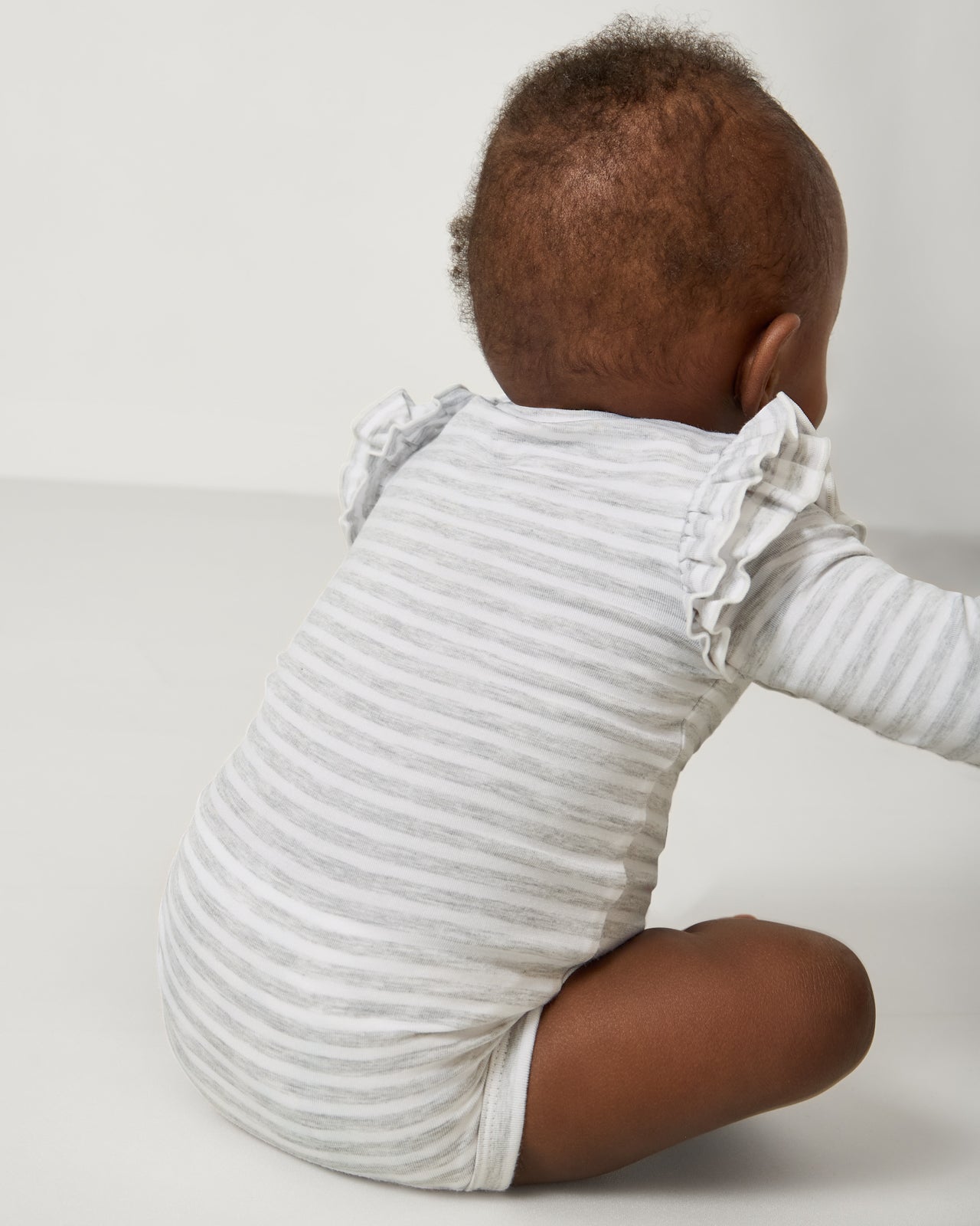 Back view of baby wearing the Light Heather Gray Stripe Flutter Bodysuit