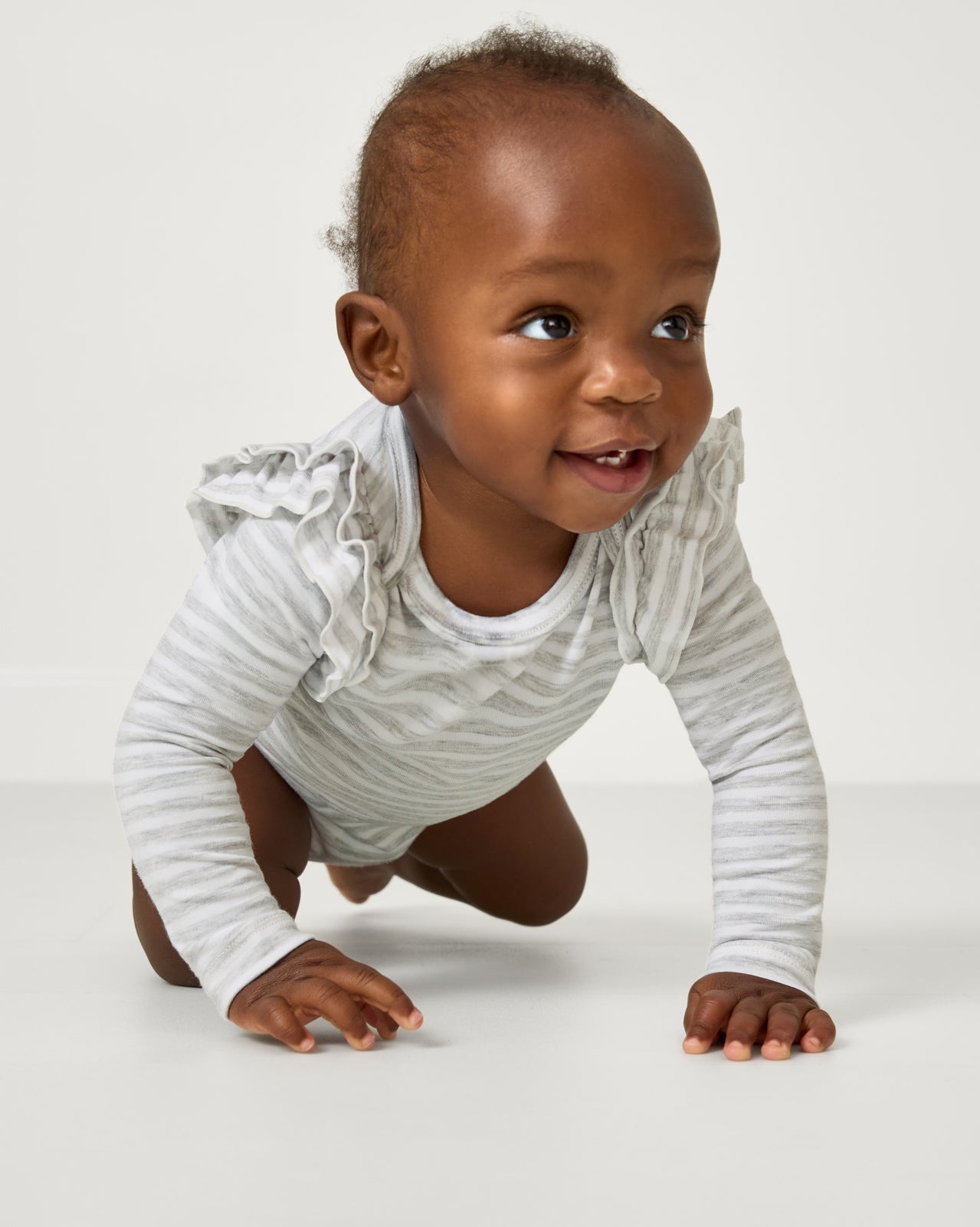 Close up of crawling child wearing the Light Heather Gray Stripe Flutter Bodysuit