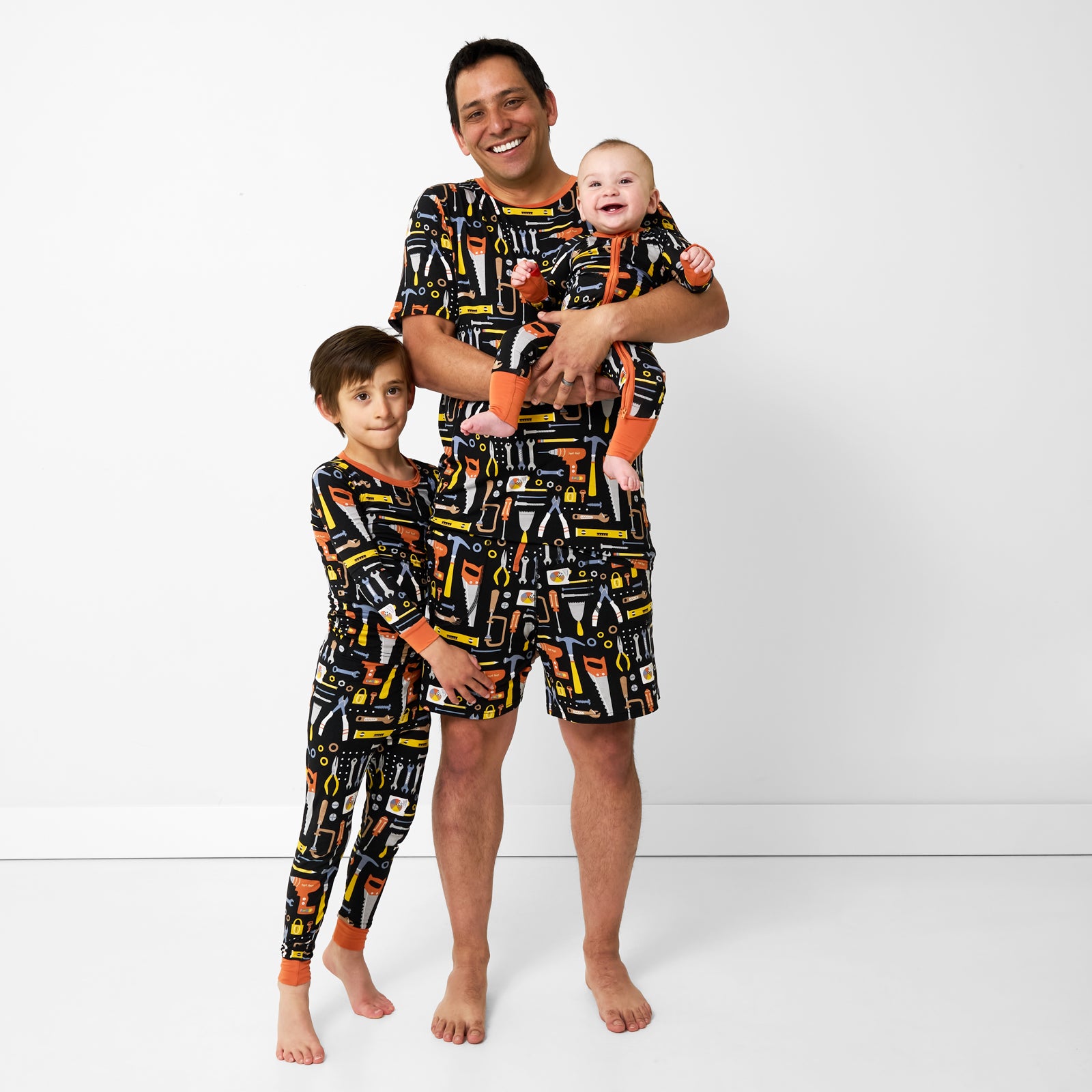 Father and two children wearing matching Little Builders pajamas
