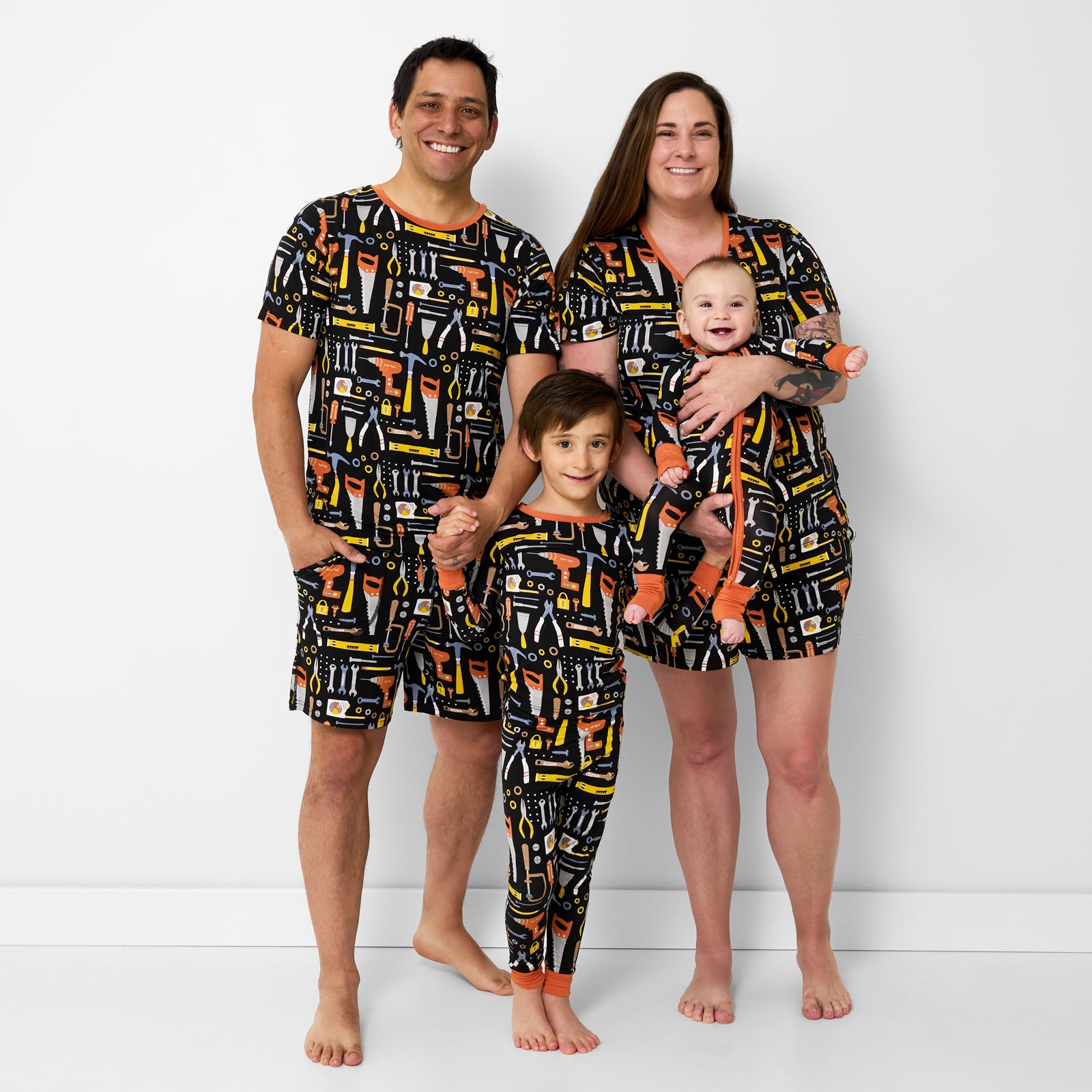 Family of four wearing matching Little Builders pajamas