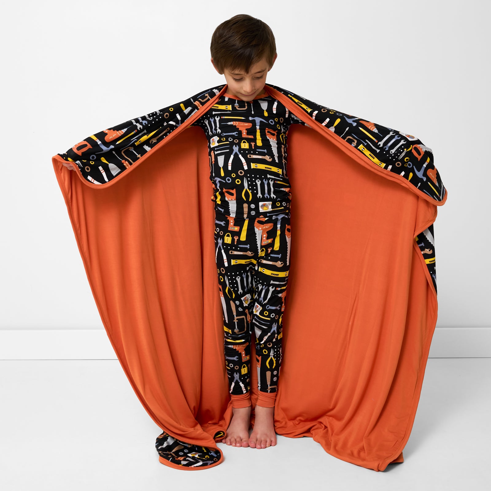 Standing child holding up the Little Builders Large Cloud Blanket®