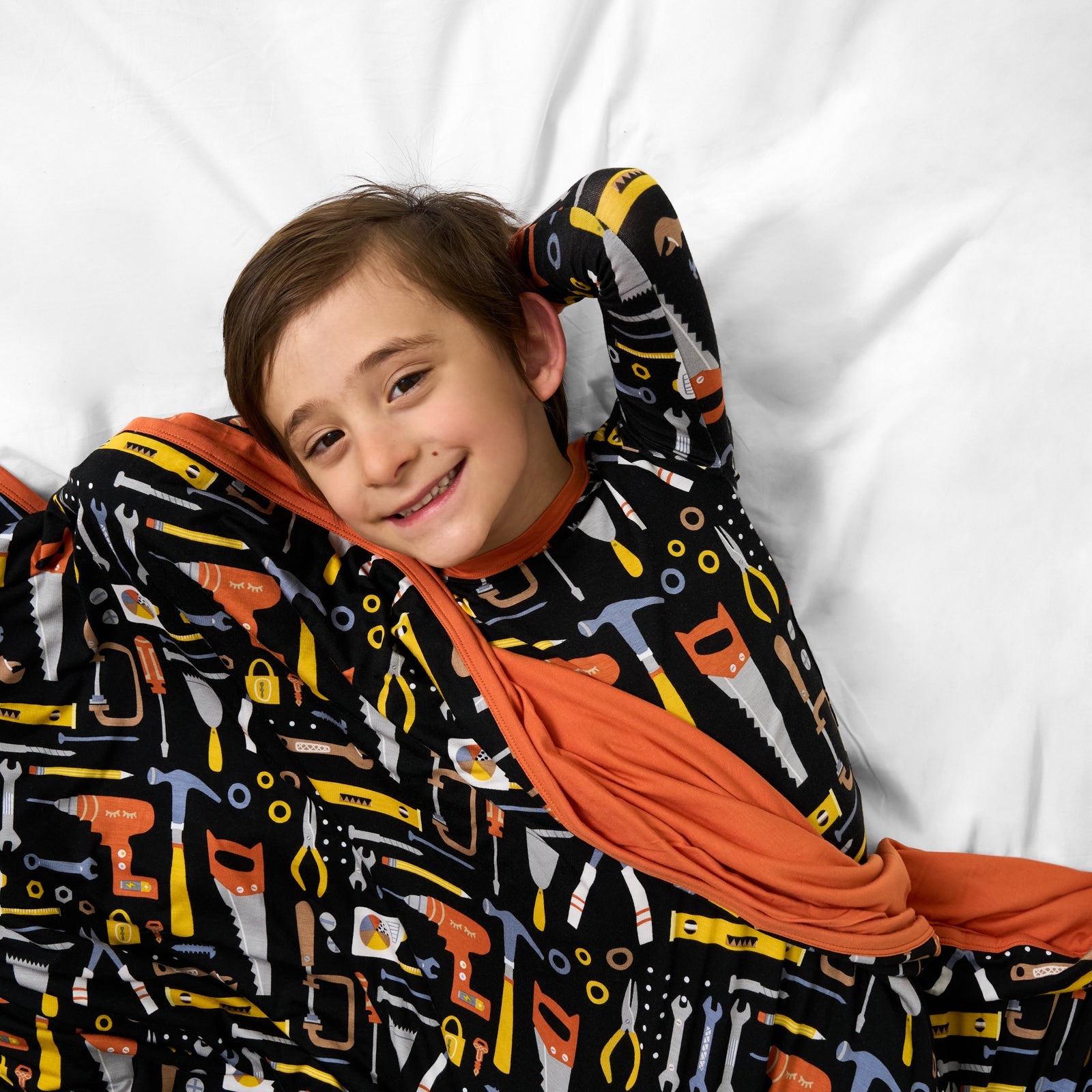 Child laying with the Little Builders Large Cloud Blanket®