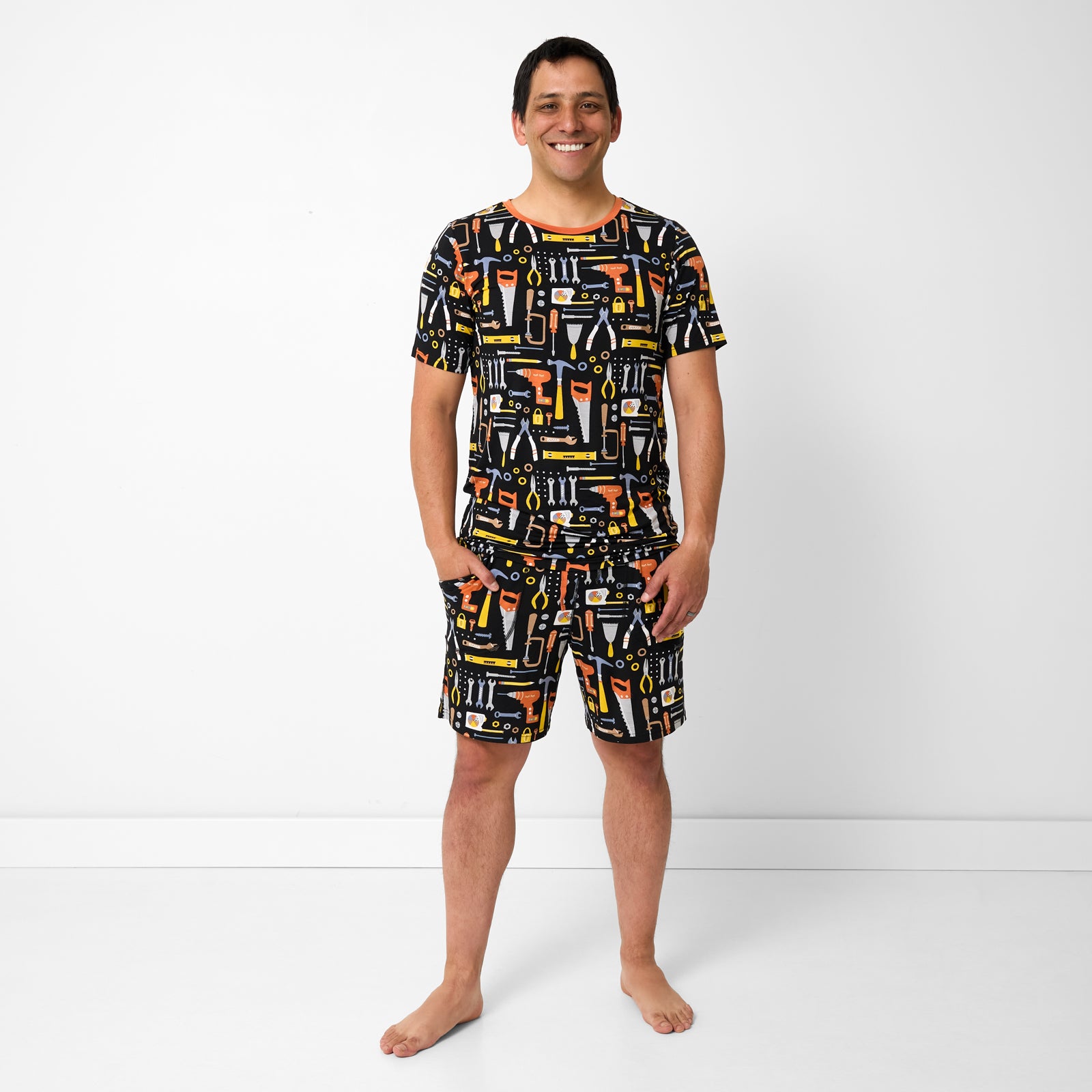 Standing man wearing the Little Builders Men's Short Sleeve Pajama Top and matching shorts
