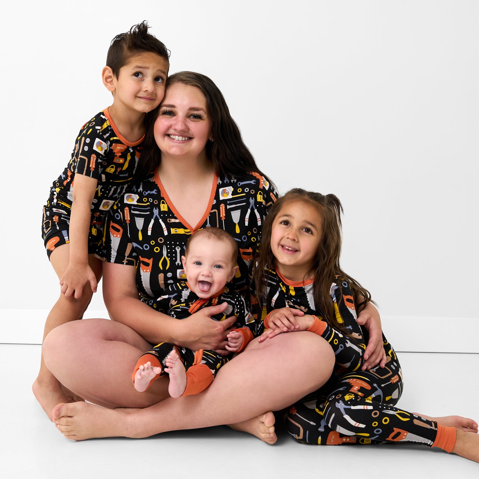 Mother and three children wearing matching Little Builders pajamas