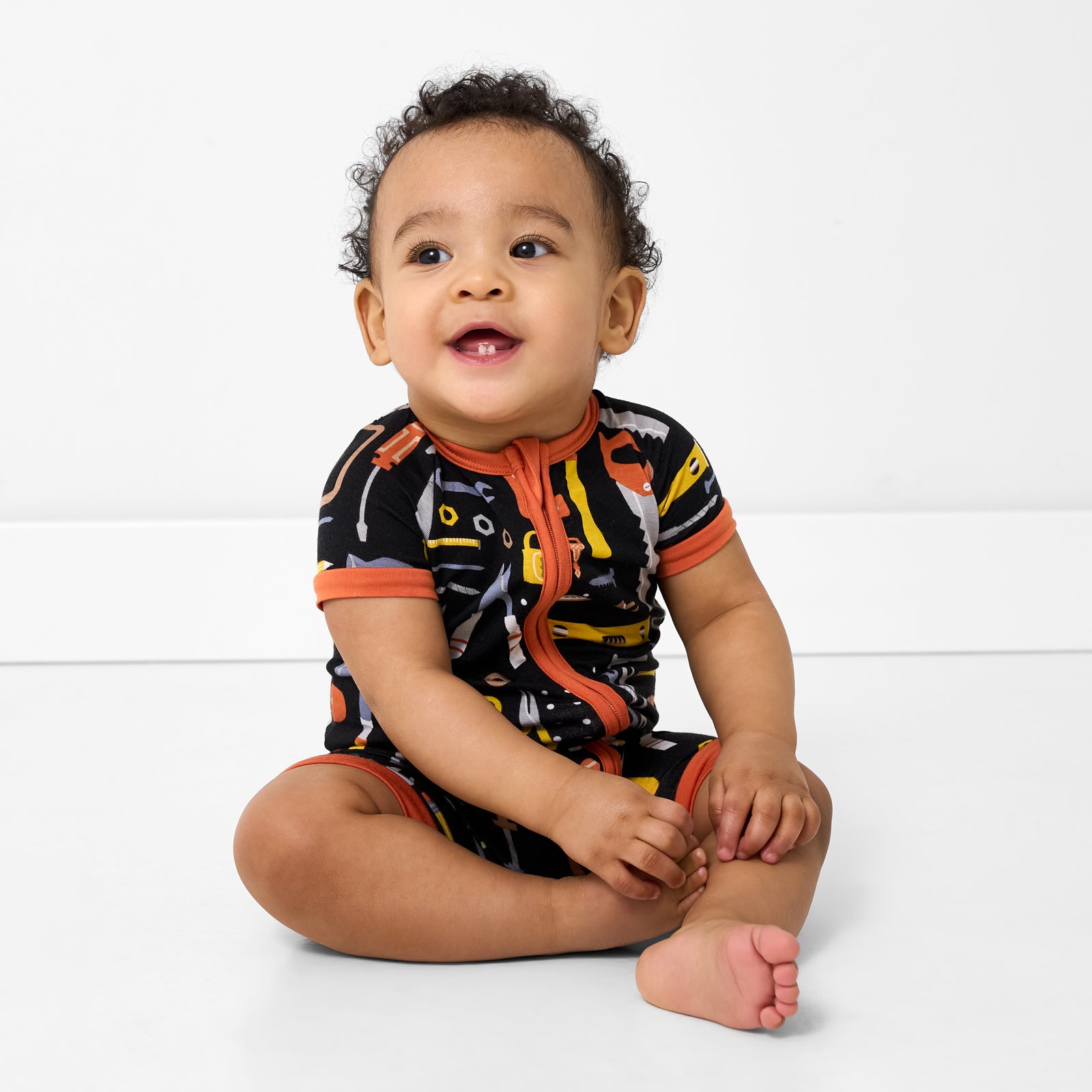 Sitting child wearing the Little Builders Shorty Zippy