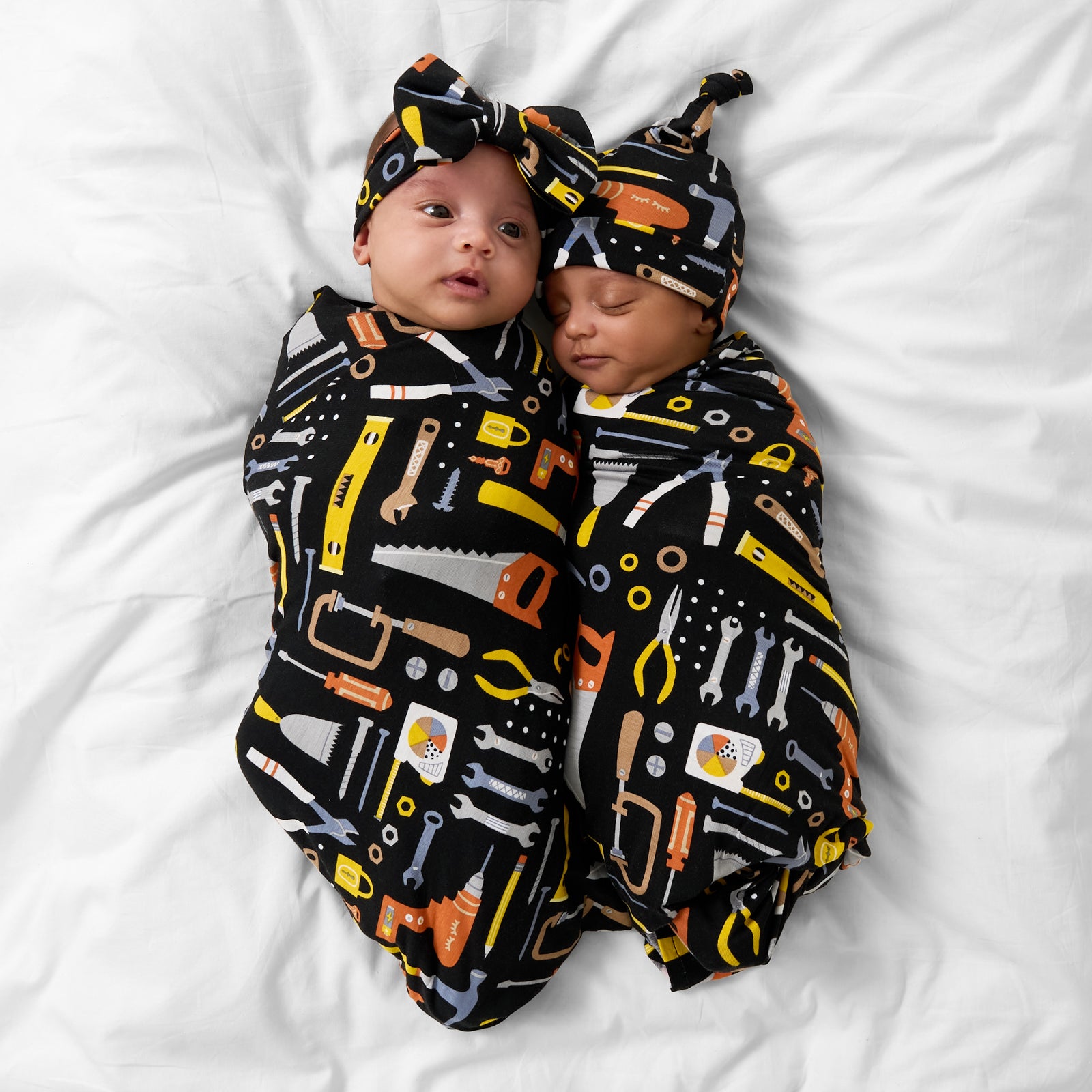 Two children wearing matching Little Builders swaddle sets