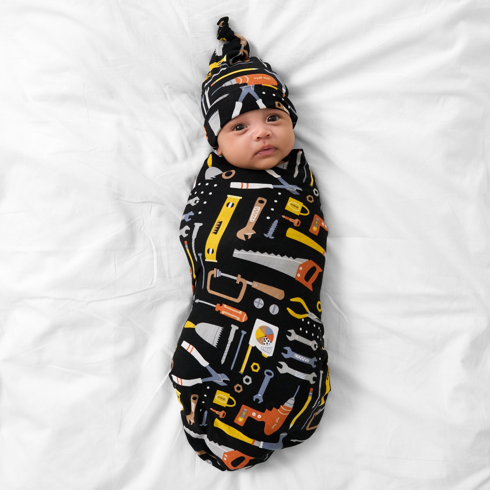 Aerial view of child wearing the Little Builders Swaddle & Hat Set
