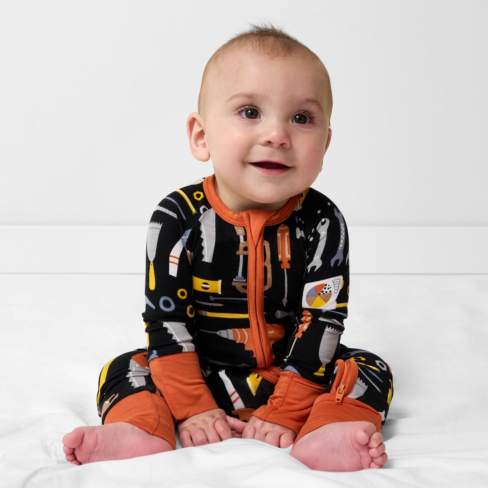 Sitting child wearing the Little Builders Zippy