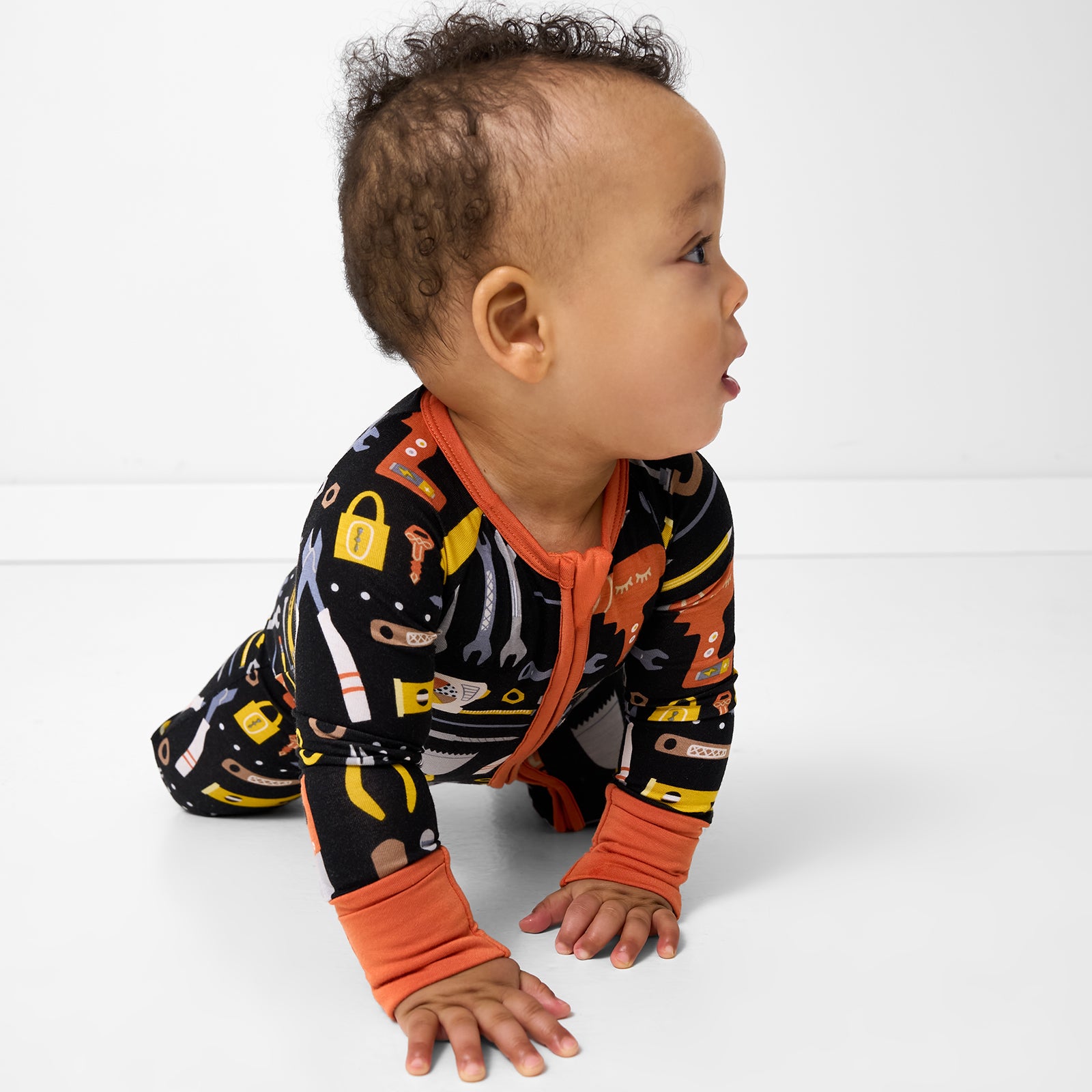 Crawling child wearing the Little Builders Zippy