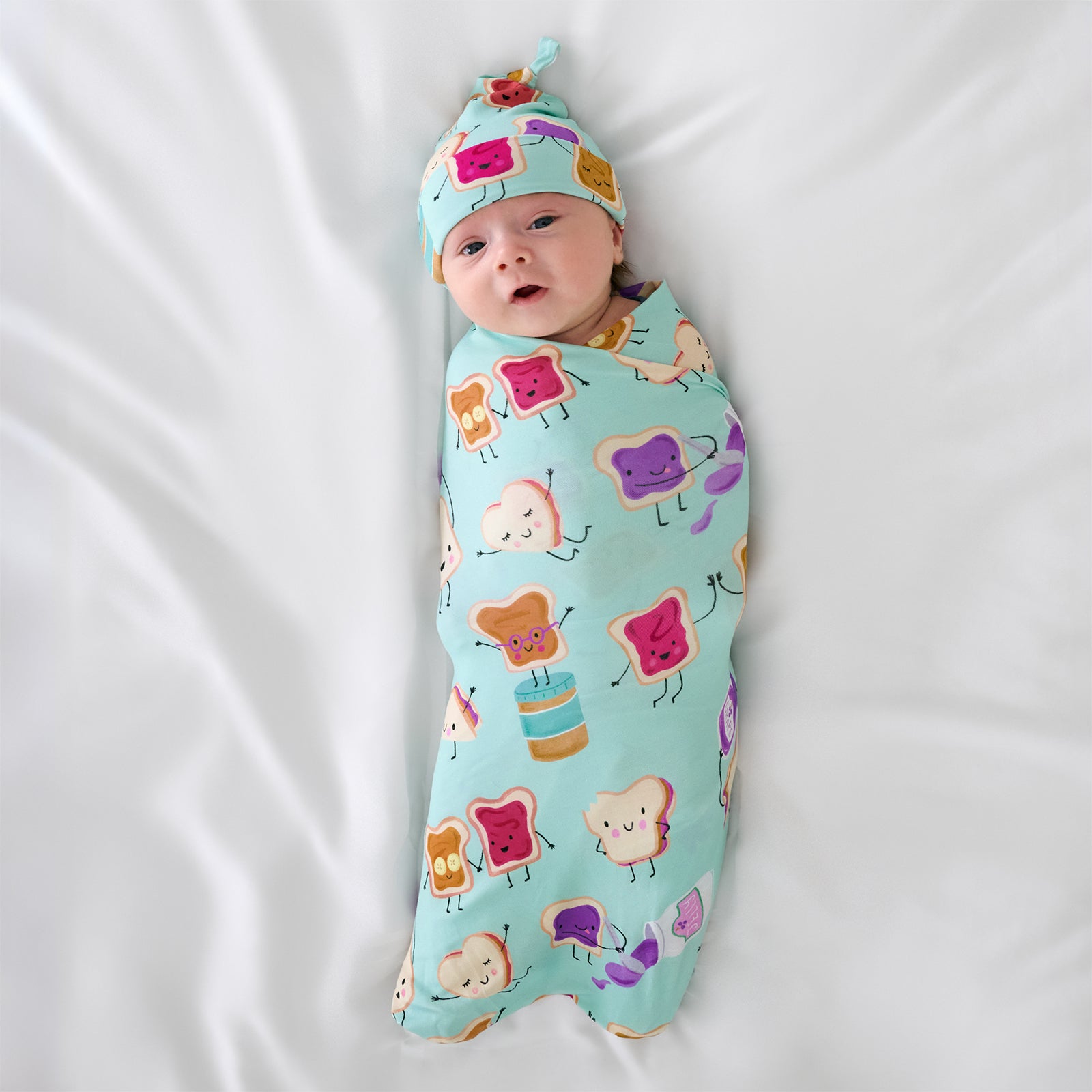 Aerial view of child wearing the Lunch Buddies Swaddle & Hat Set