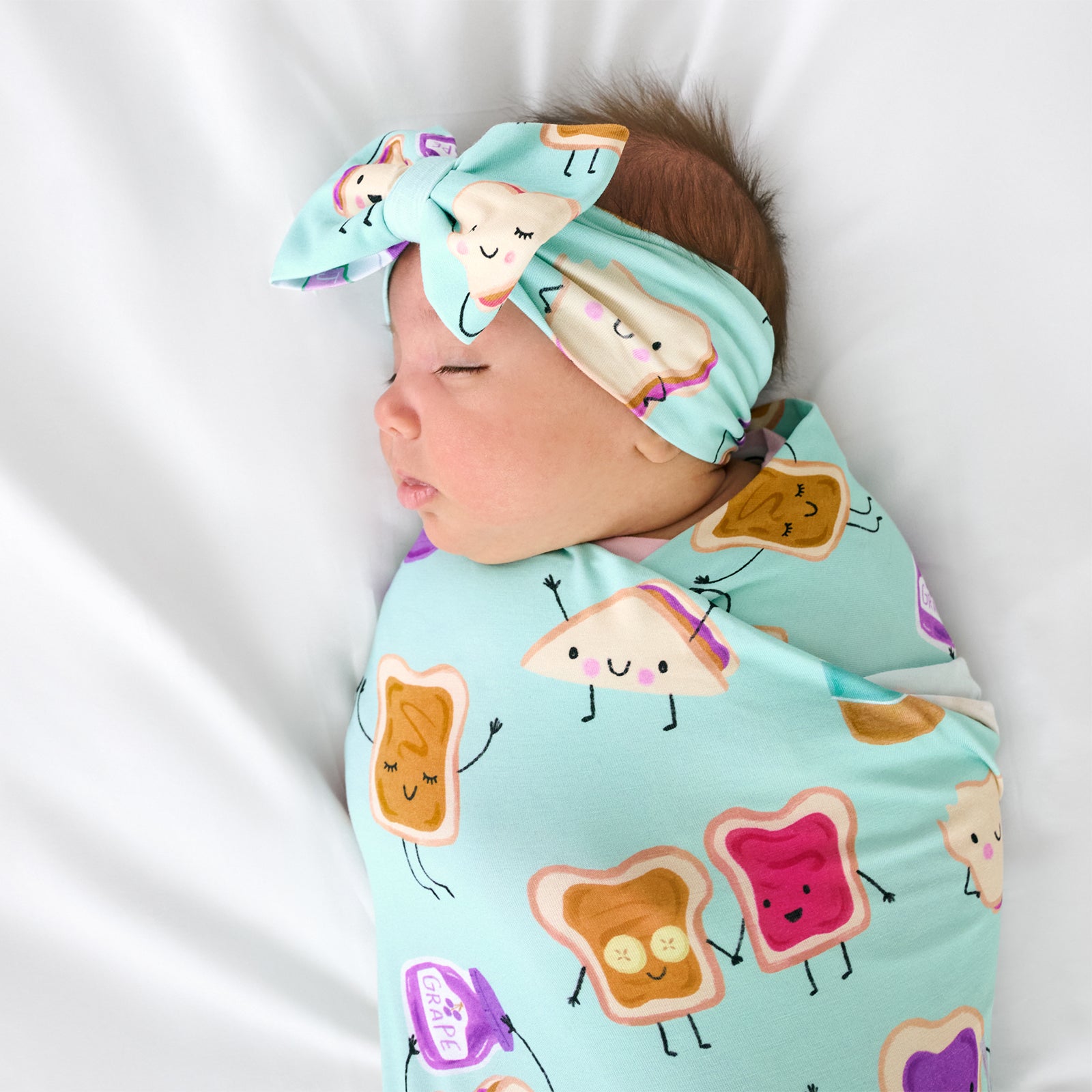 Close up of child wearing the Lunch Buddies Swaddle & Luxe Bow Headband Set