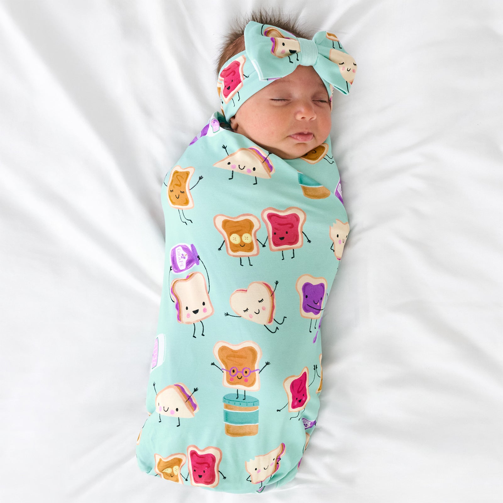 Aerial view of child wearing the Lunch Buddies Swaddle & Luxe Bow Headband Set