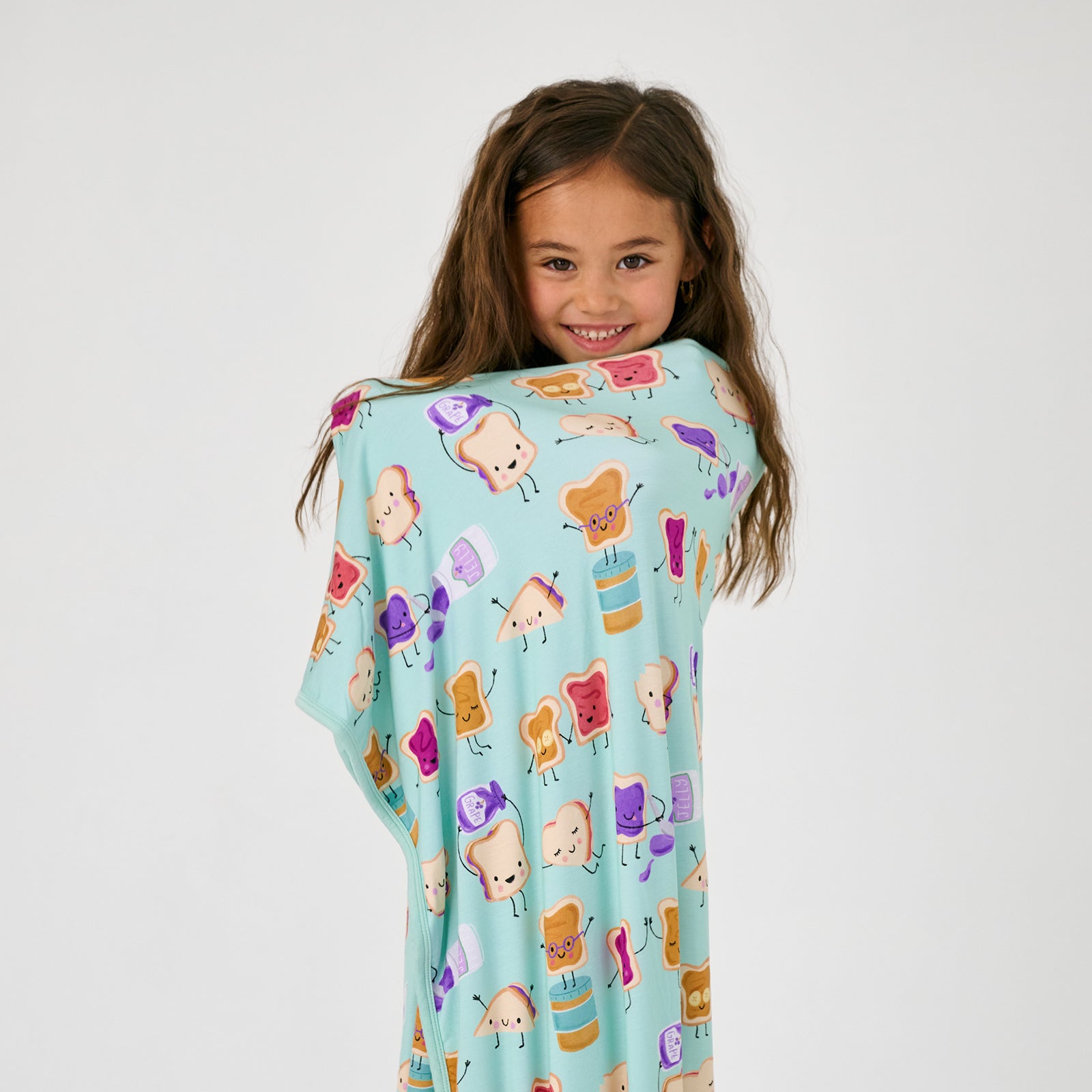 Standing child wrapped in the Lunch Buddies Large Cloud Blanket®