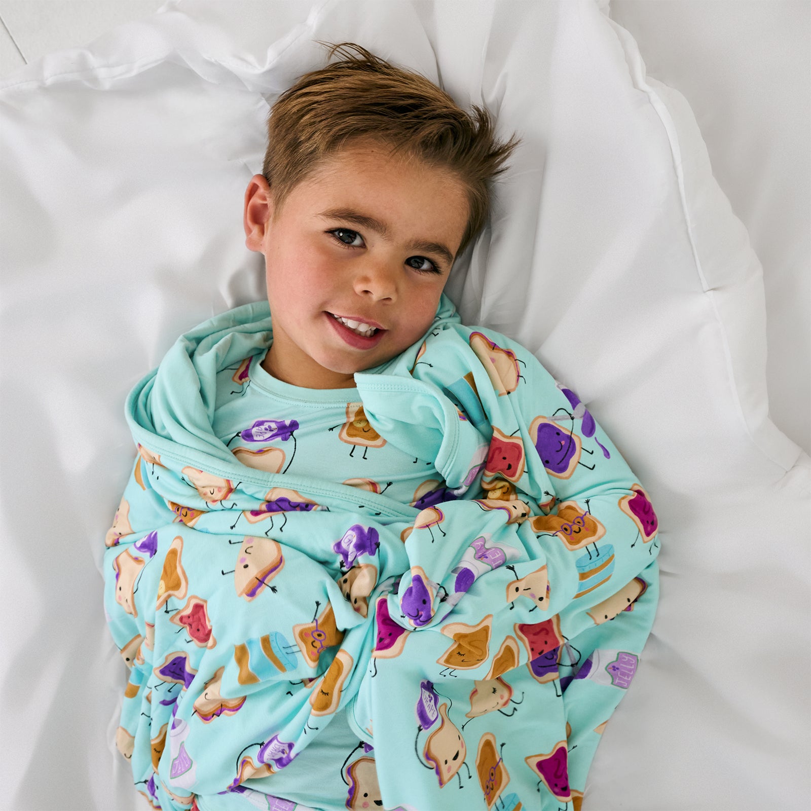Aerial view of child wrapped in the Lunch Buddies Large Cloud Blanket®